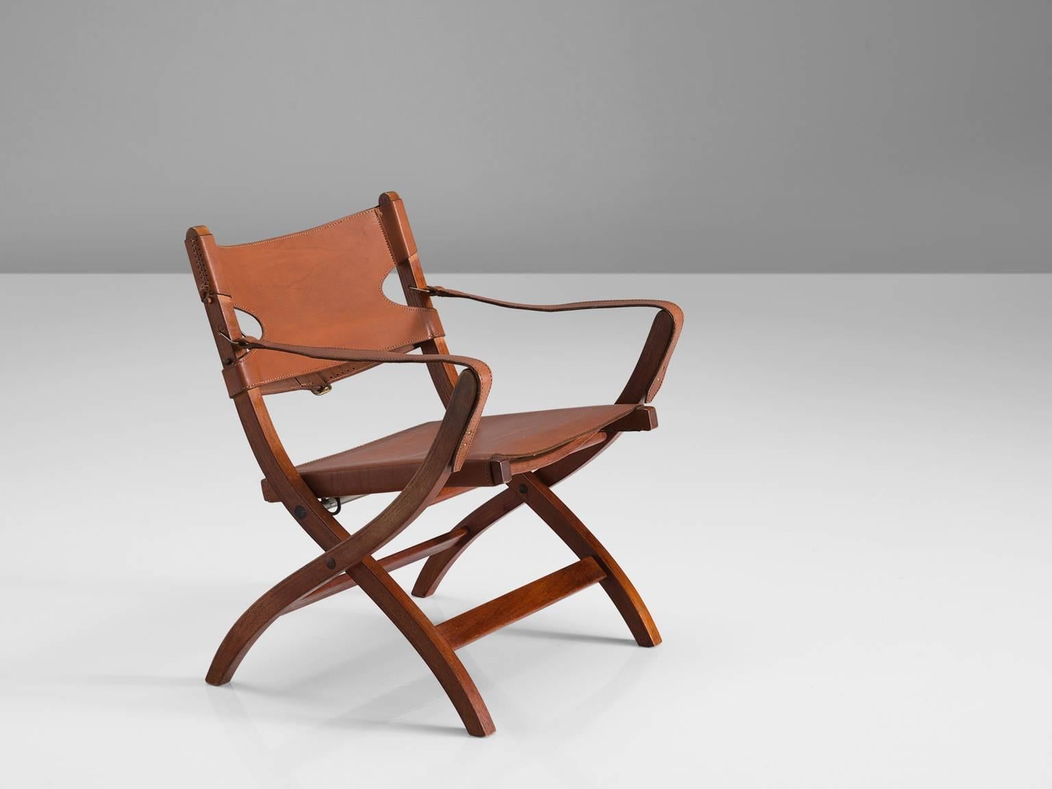 Poul Hundevad, folding chair, in oak and leather, Denmark, 1950s.

This folding chair has X-shaped legs, and is inspired on ancient Egyptian thrones and chairs. The frame is from solid oak. The seating and back are made of cognac colored to brown