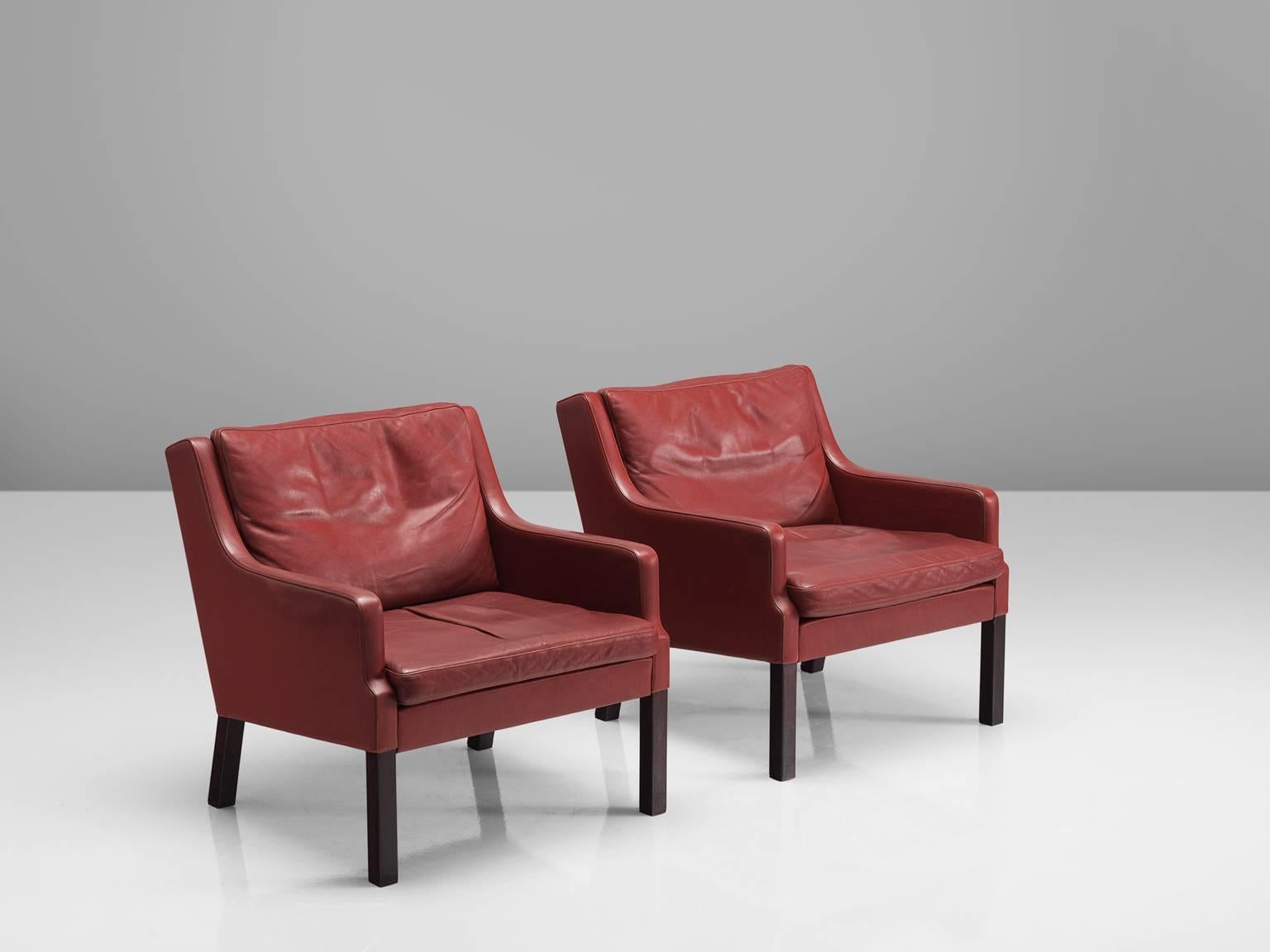 Lounge chairs, leather, mahogany, Denmark, circa 1960s–1970s.

This set is quintessentially Danish. Comfortable, well made and simplistic in design yet rich in use of material and finished. The set features patinated red to brown leather and