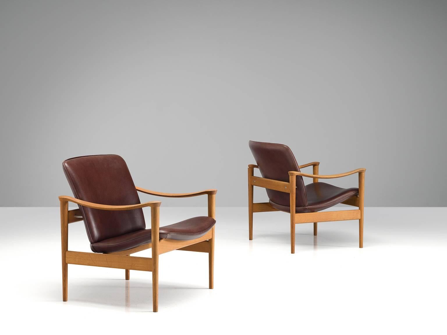 Fredrik A. Kayser for Vatne Lenestolfabrikk, armchairs model 711, oak and faux leather, Norway, 1960.

This set of chairs is designed by Frederik A. Kayser and executed by Vatne Lenestolfabrikk. The armchair are executed in oak, leatherette and