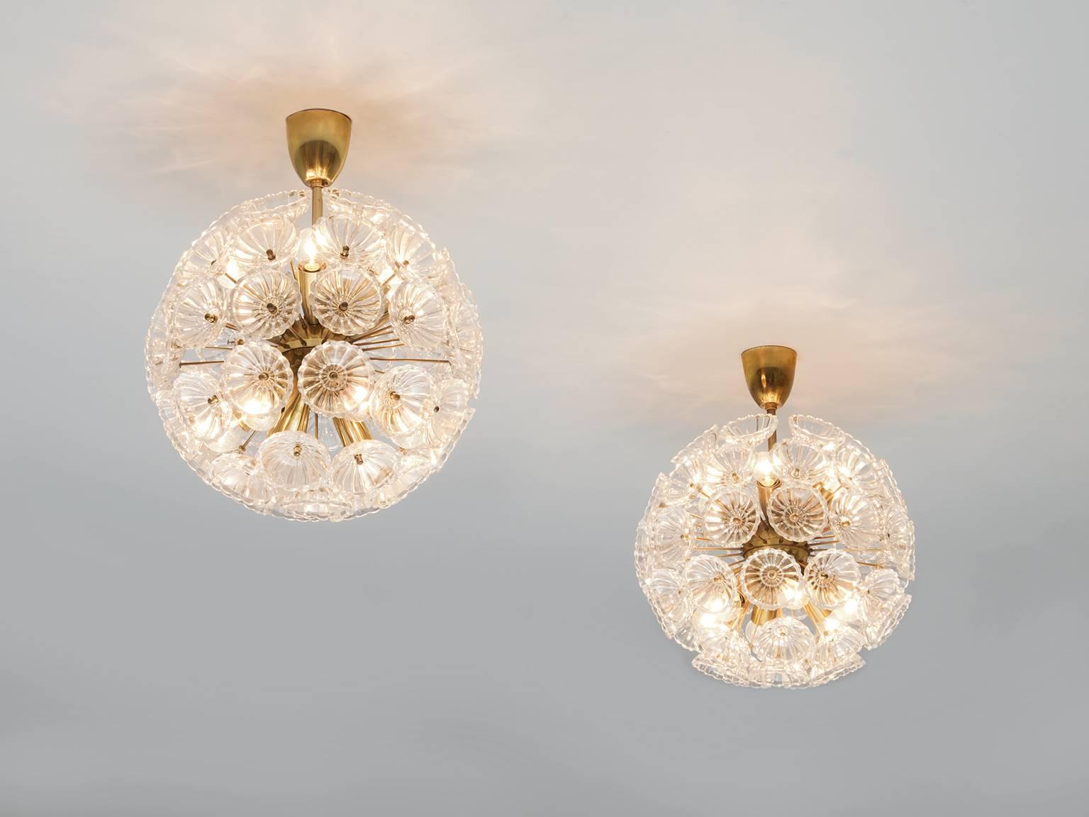 Sputnik chandeliers, in glass and brass, Austria, 1950s. 

Large brass 'flower' Sputnik chandeliers, made in Vienna in the 1950s, in the style of Emil Stejnar. The set consists of glass flowers with a brass frame that are playful and classic at the
