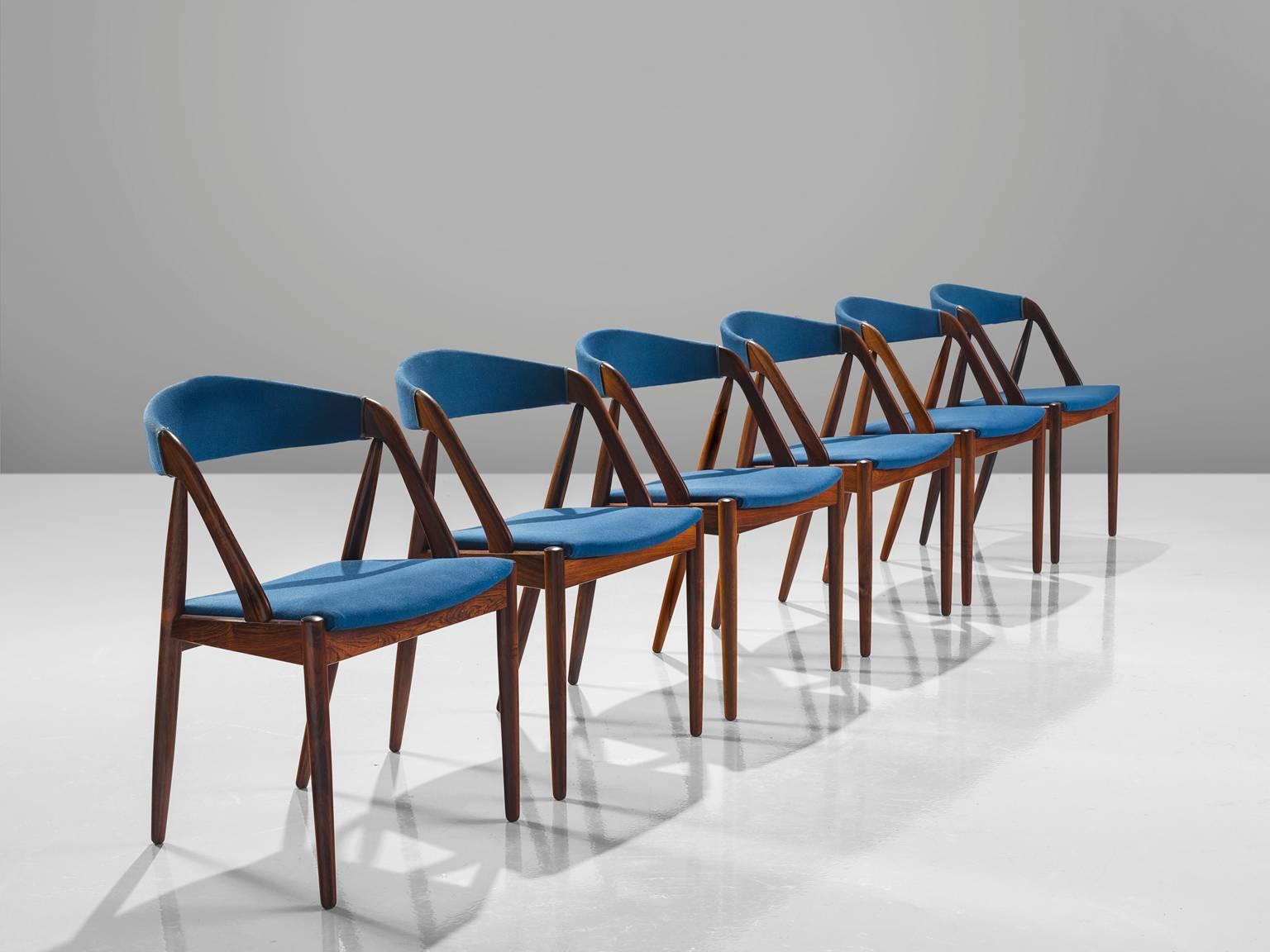 Kai Kristansen for Schou Andersen, six dining chairs model 31, in rosewood and blue fabric, Denmark, 1950s.

Set of six armchairs by Danish designer Kai Kristiansen. These sculptural chairs show beautiful lines and curves and are executed in