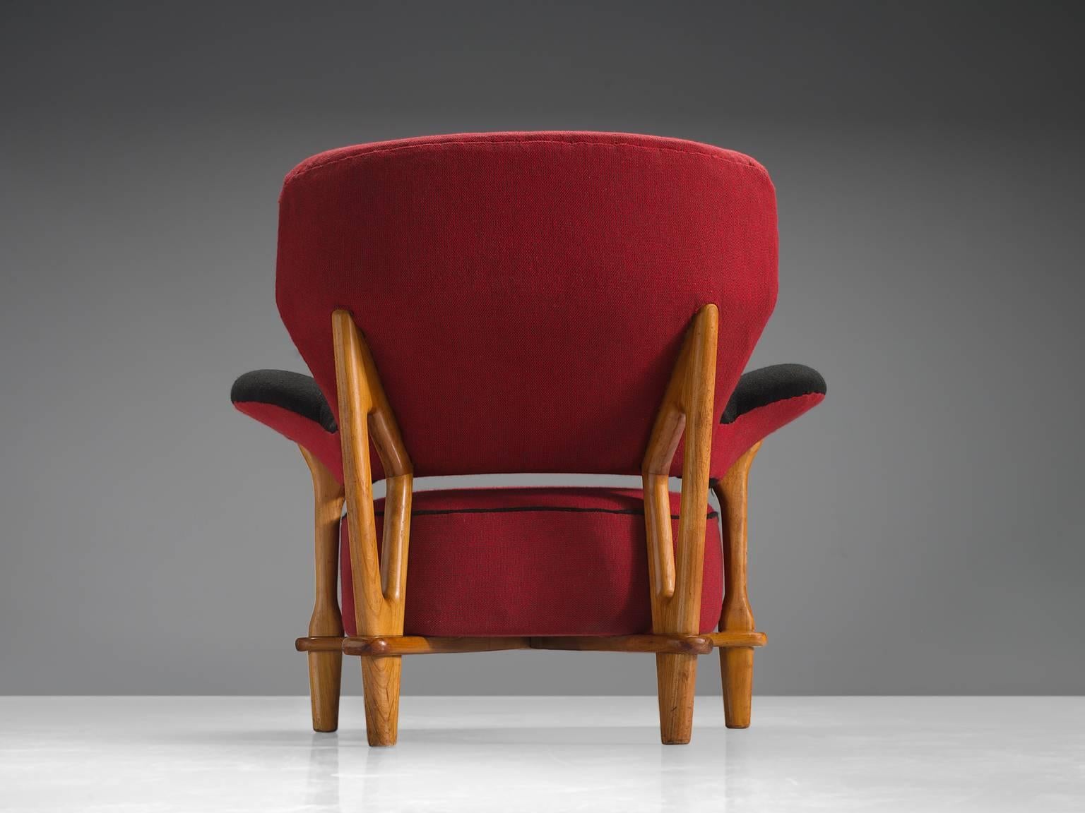Theo Ruth for Artifort, armchair, beech, red fabric, the Netherlands, 1950s.

This velvet, voluptuous armchair by Theo Ruth is a very strong singular item. The back flows with a natural grace into the armrests. The open gap between the backrest and