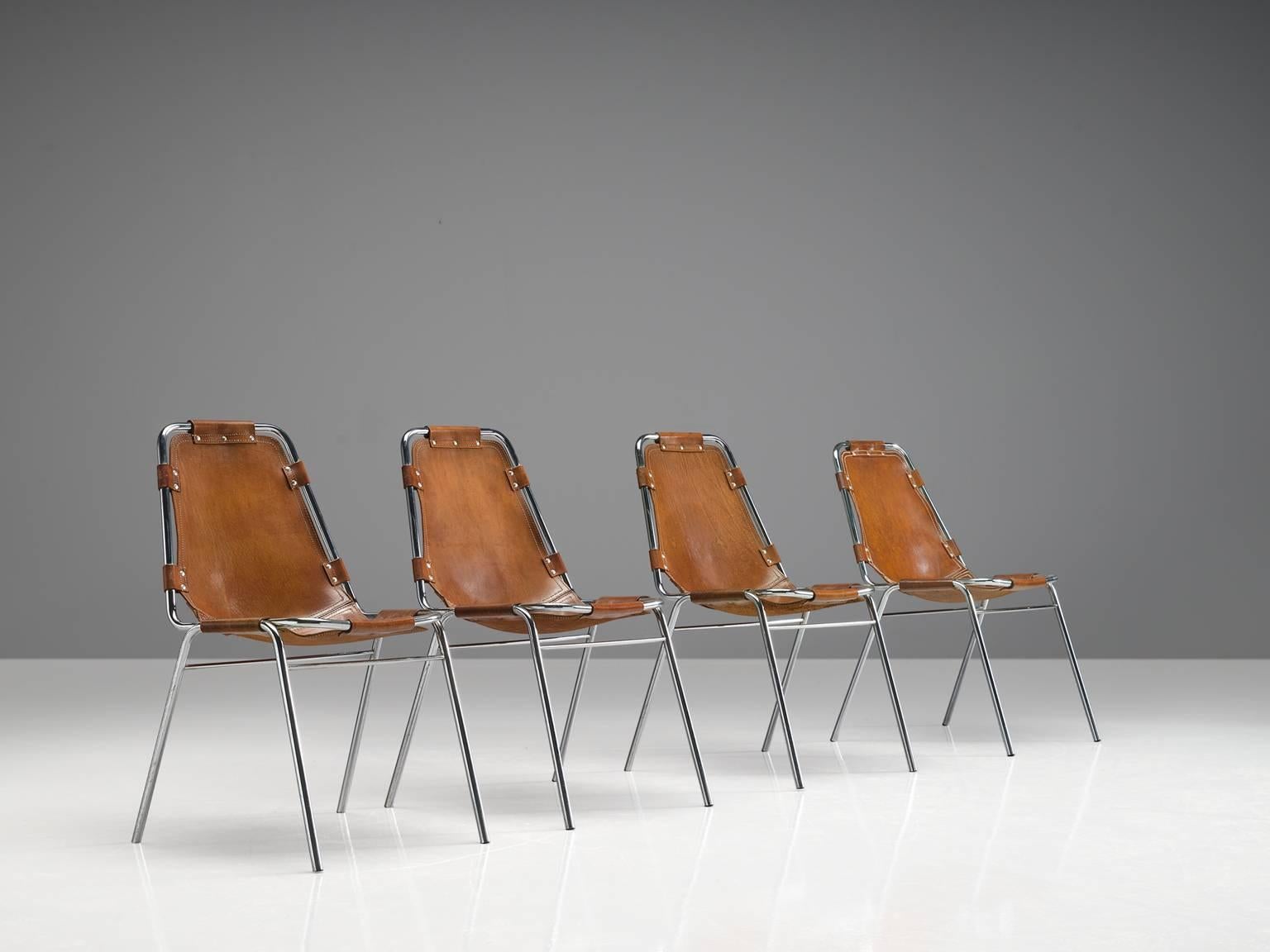 Set of four chairs, in steel and leather, France, circa 1970s. 

Set of four chairs of the famous model 'Les Arcs.' The simplistic design consists of a tubular steel frame with a seating of thick cognac saddle leather. The natural leather makes a