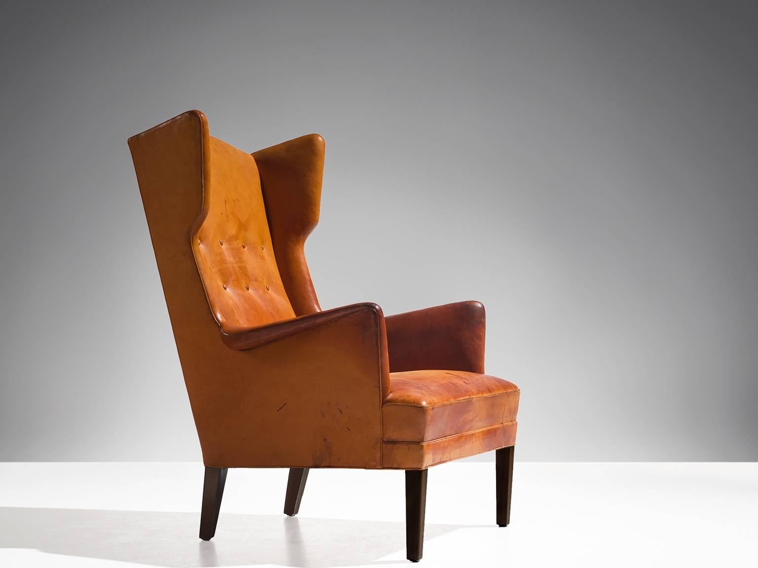 Frits Henningsen, lounge chair, cognac leather and stained wood, Denmark, 1950s. 

Rare wingback chair attributed to the Danish designer Frits Henningsen. This chair shows the lines of a classical chair, yet combined with just enough modern