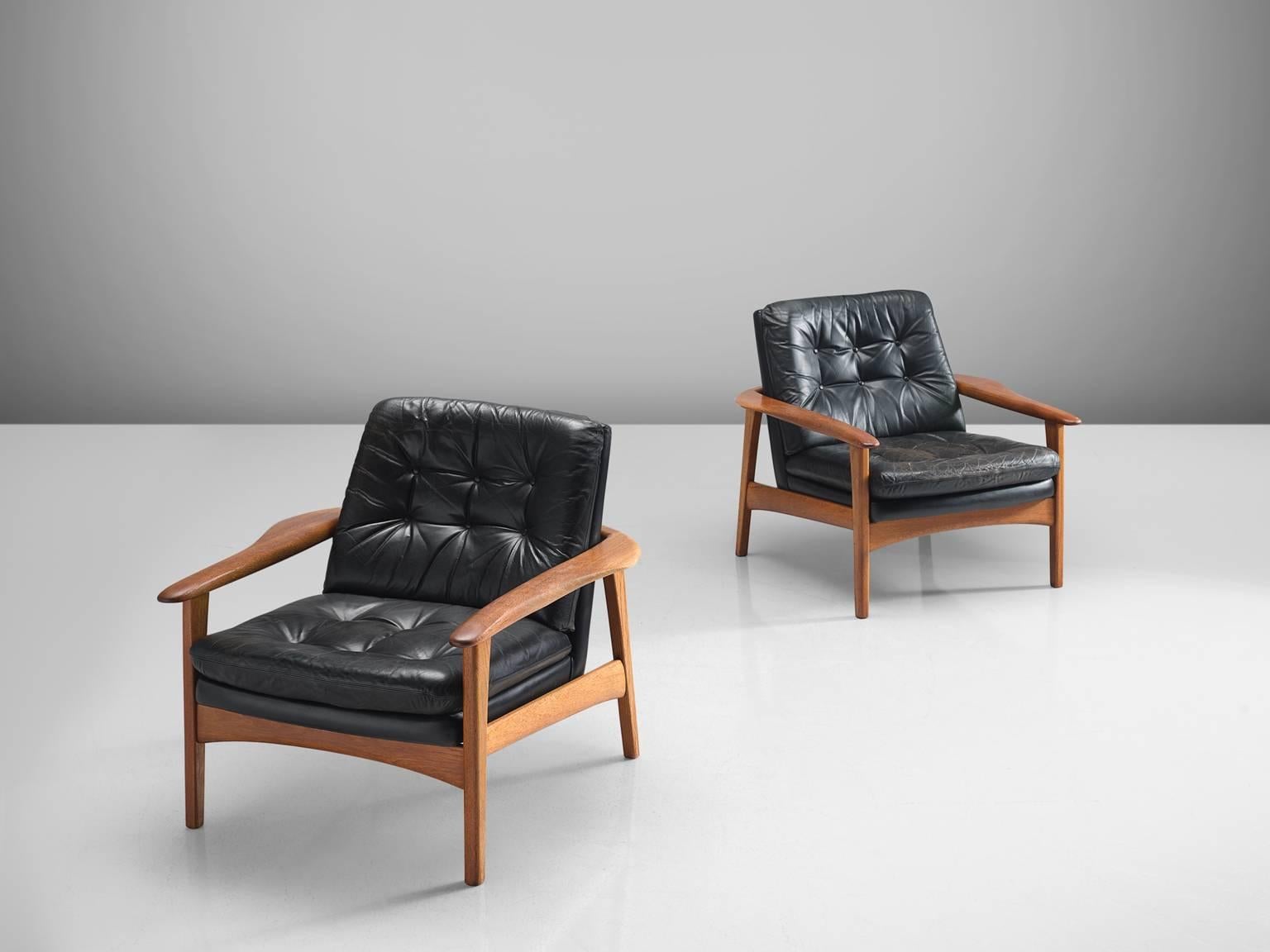 Pair of easy chairs, black leather and teak, Denmark, 1960s.

This set of chairs is part of the midcentury design collection. The back and seat are upholstered in a black tufted leather. The armrest are curved and flow slightly inwards. The chair's