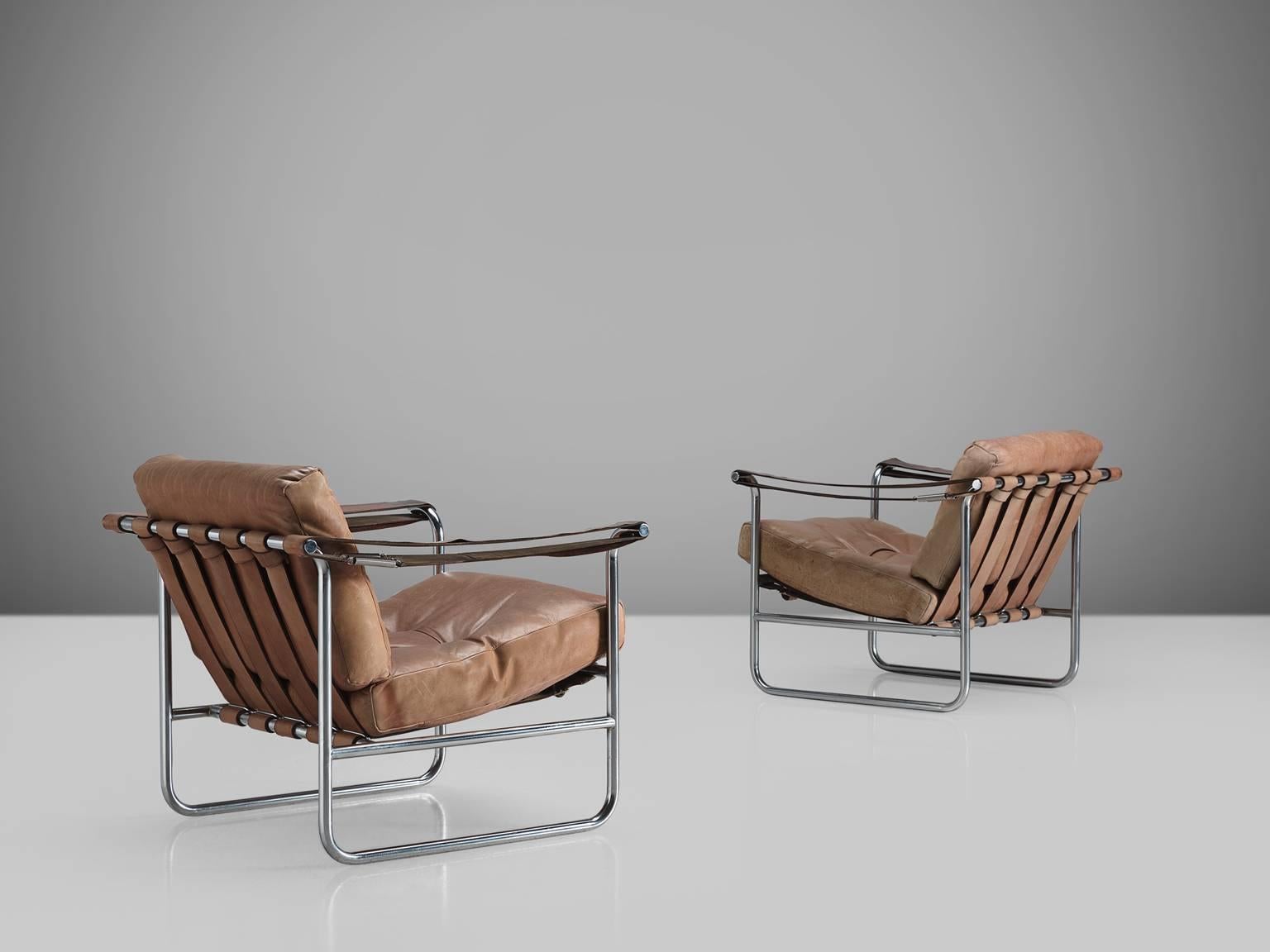 Hans Eichenberger for De Sede, set of armchairs HE 113, beige to cognac leather, tubular steel, Switzerland, 1956.

This set of Swiss armchairs features a tubular frame with a thick comfortable seat and back cushion. The back of the chairs is
