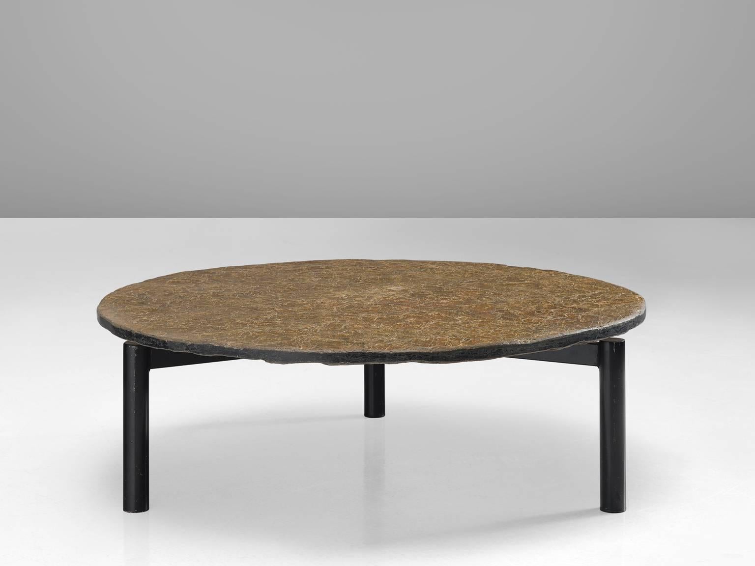 Cocktail table, slate, metal, Northern-Europe, 1970s. 

This organic and robust coffee or cocktail table is from the 1970s and is part of the midcentury design collection. The thick round top is supported by a metal tripod frame that shows traits of