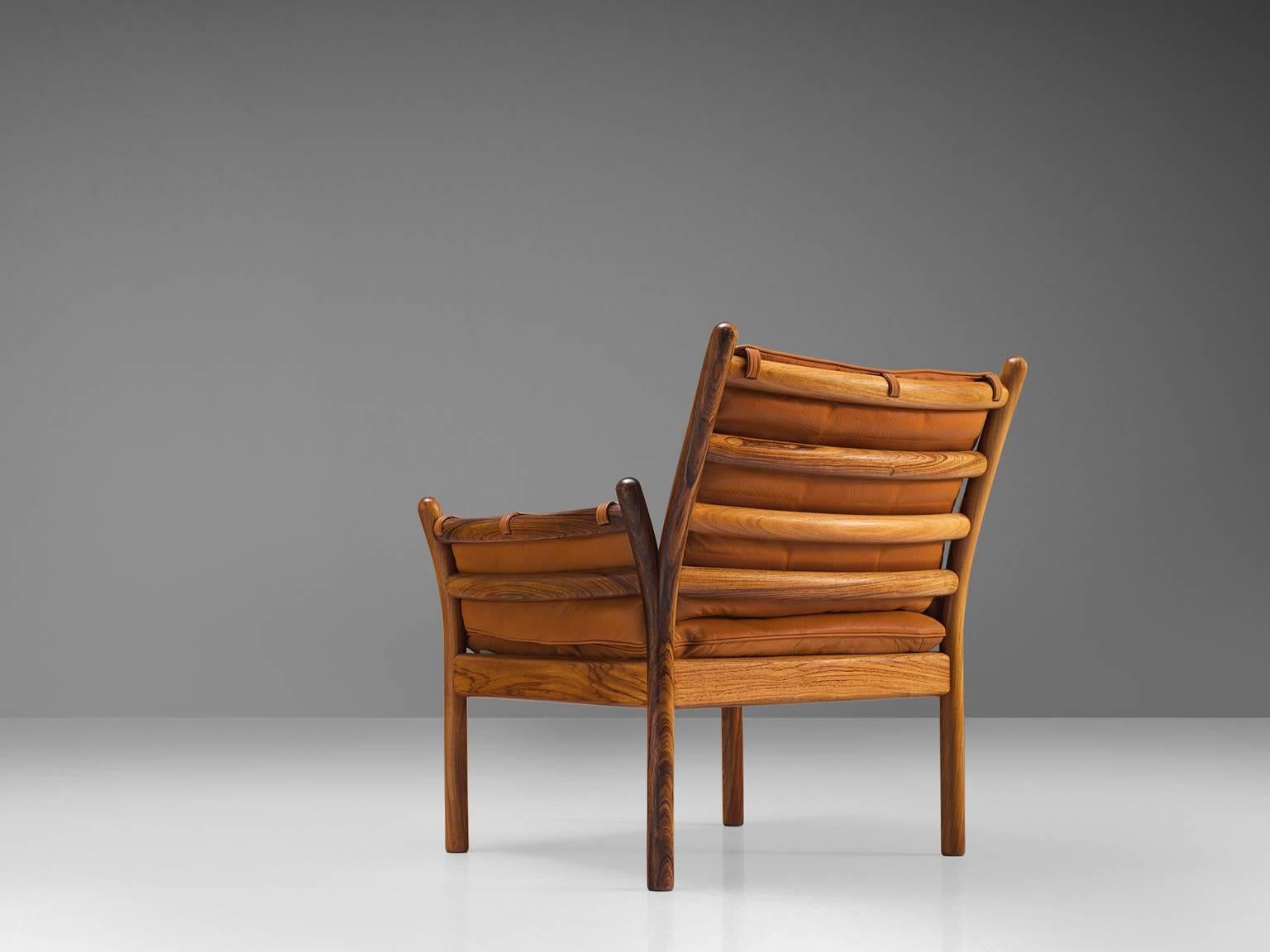 Illum Wikkelsø by CFC Silkeborg, 'Genius' chair, leather and rosewood, Denmark, 1950s.

This chair is made out of solid rosewood and features a cognac leather cushion on both seat and back.. The chair is created as a sort of slatted rosewood basket.