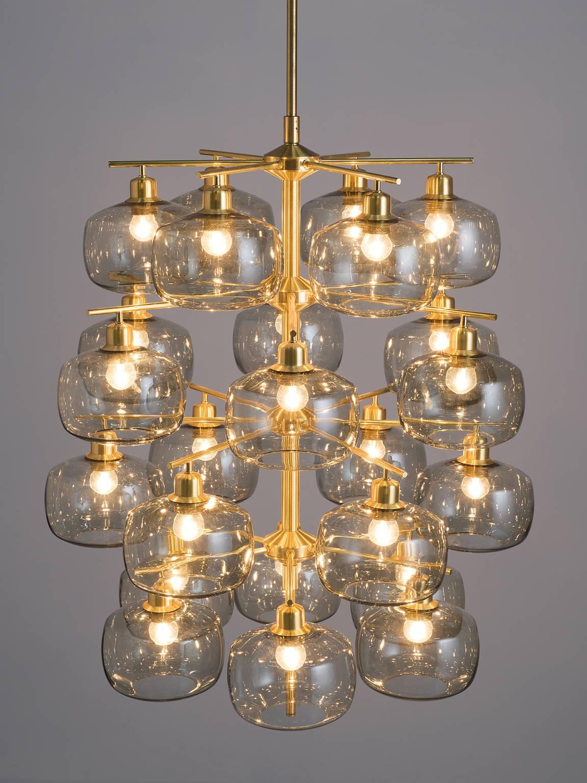 Holger Johansson for Westal, eight chandeliers, brass, smoked glass, Sweden, 1952

This large set of exceptional chandeliers feature a brass frame and translucent bulbs that resemble 'pressed' spheres. These Midcentury pendants are original thanks