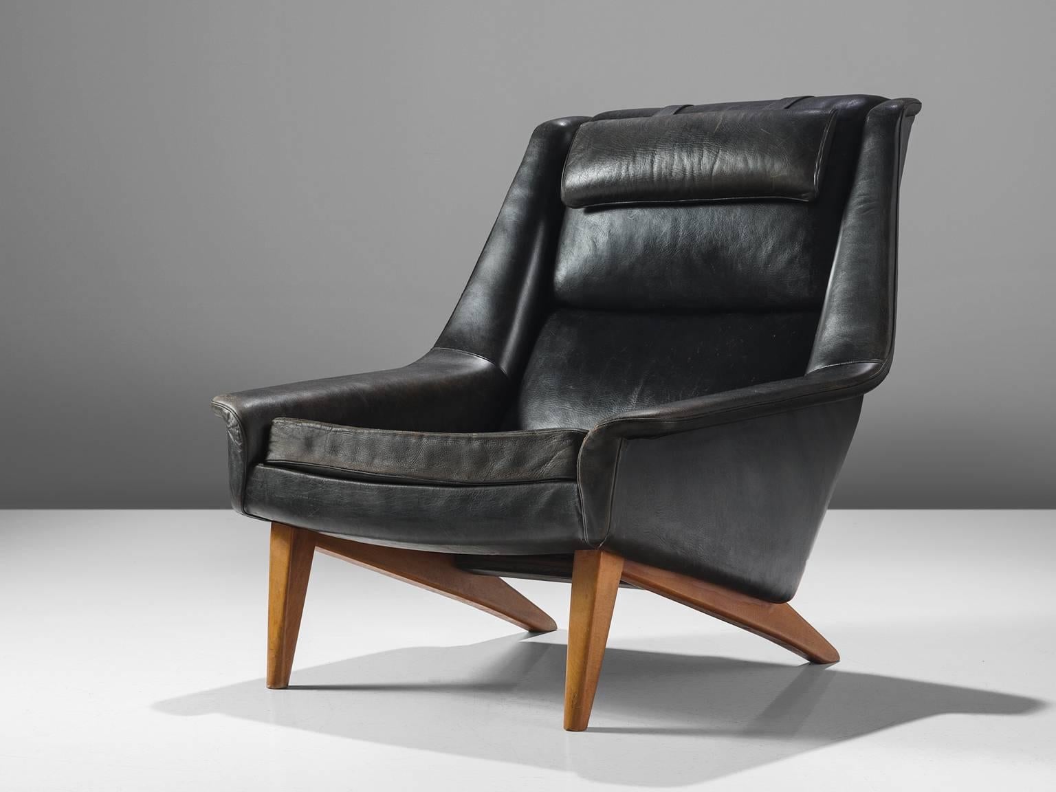 Folke Ohlsson for Fritz Hansen, lounge chair, in black leather and teak, by Denmark, before 1957. 

This chair by Fritz Hansen, high quality lounge chair is made to reach an ultimate level of comfort as can clearly be recognized in the design. Very