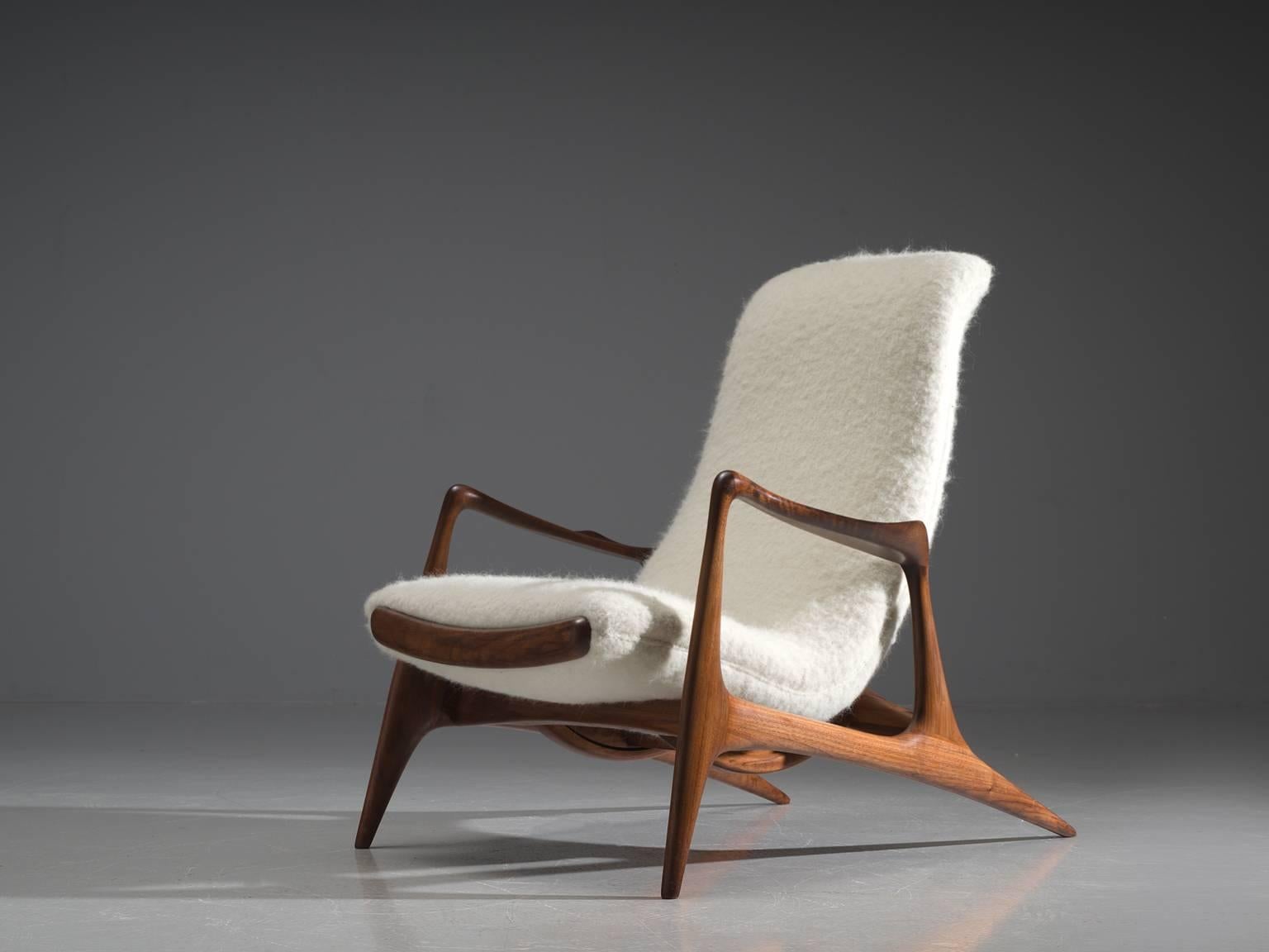 Vladimir Kagan for Dreyfuss, contour chair, walnut and white wool, United States, 1950s.

This lounge chair by Kagan is sculptural and delicate. The frame, executed in American walnut is carved and detailed in an exquisite manner. The back legs