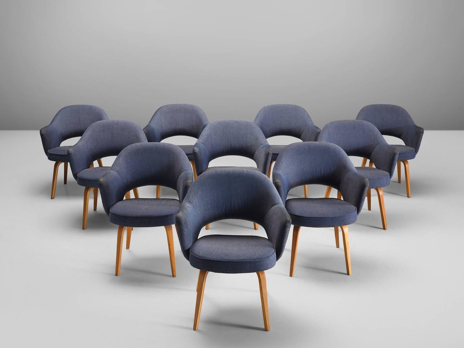 Eero Saarinen for Knoll International, set of ten chairs model 71A, in wood and blue fabric, United States, 1948. 

Ten iconic armchairs designed by Eero Saarinen. This iconic model is reupholstered in a blue fabric. The chairs feature a fluid,