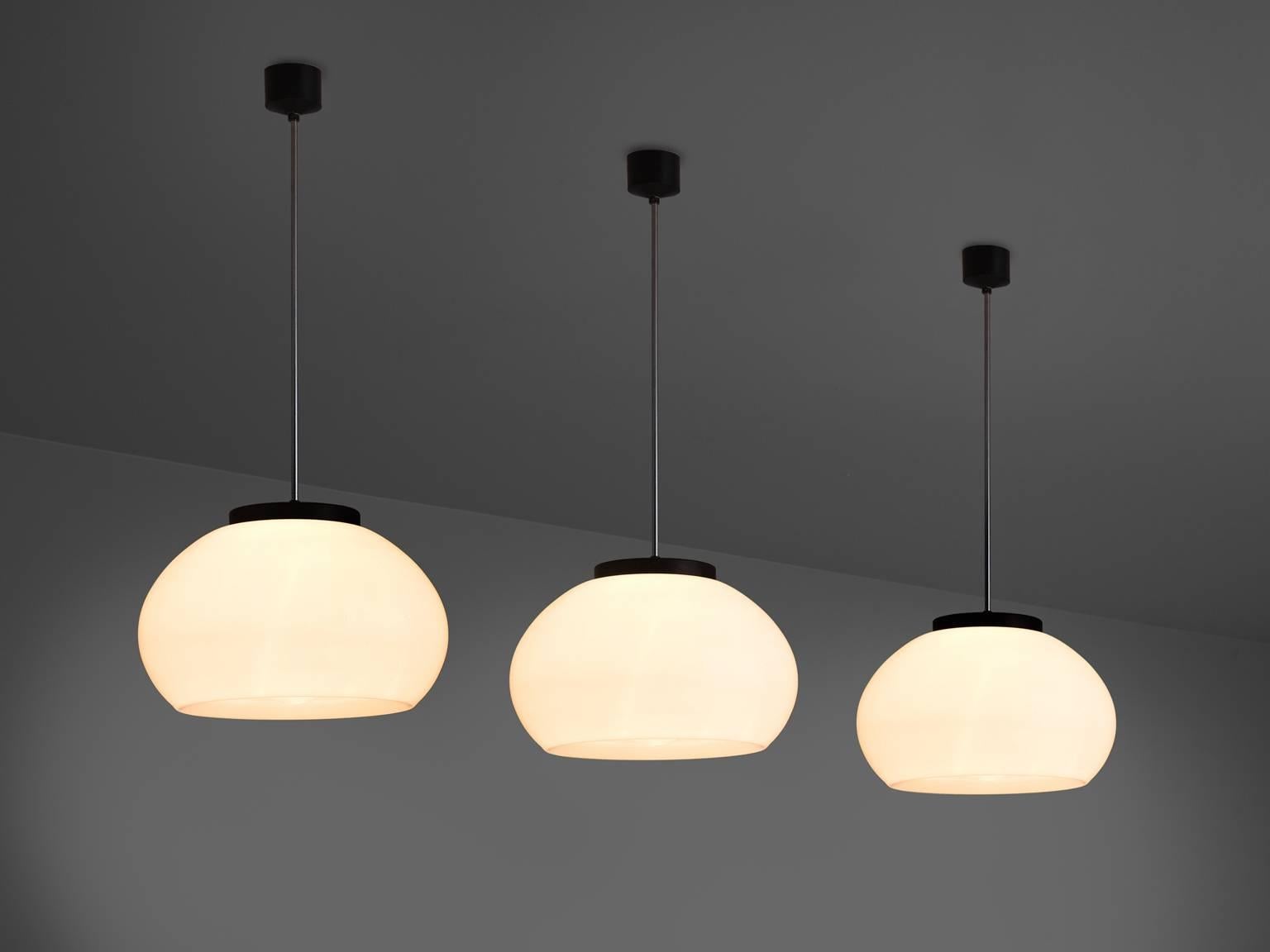Pendant, opaline glass, metal, Europe, 1970s.

This simplistic, round shape is very lush and organically shaped. The pendants are typically midcentury modern. The opaline glass results in a stunning soft light partition. The contrast of this