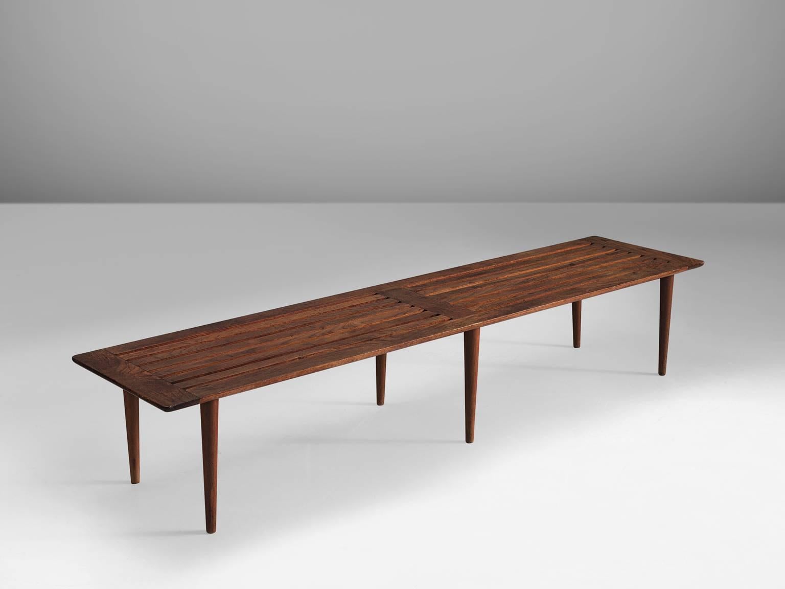 Bench, teak and oak, Denmark, 1950s.

This long wooden bench features six circular tapered legs. The bench has slats that are integrated in the seat. The bench is modest and understated in its design. Thanks to the simplicity of the design and the