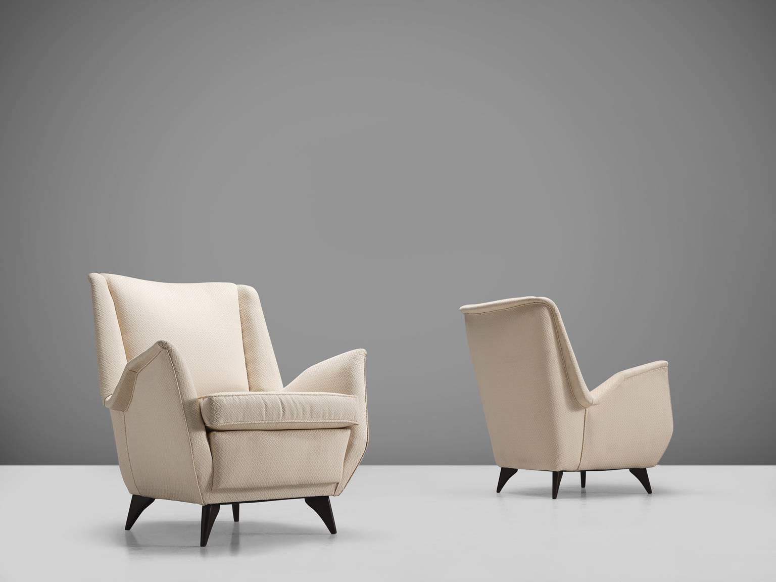 ISA, pair of lounge chairs, in white fabric and wood, Italy, 1950s. 

An elegant pair of Italian Lounge chairs in the manner of Gio Ponti. What really characterizes this chairs is their theatrical, fluent armrests and medium high back in