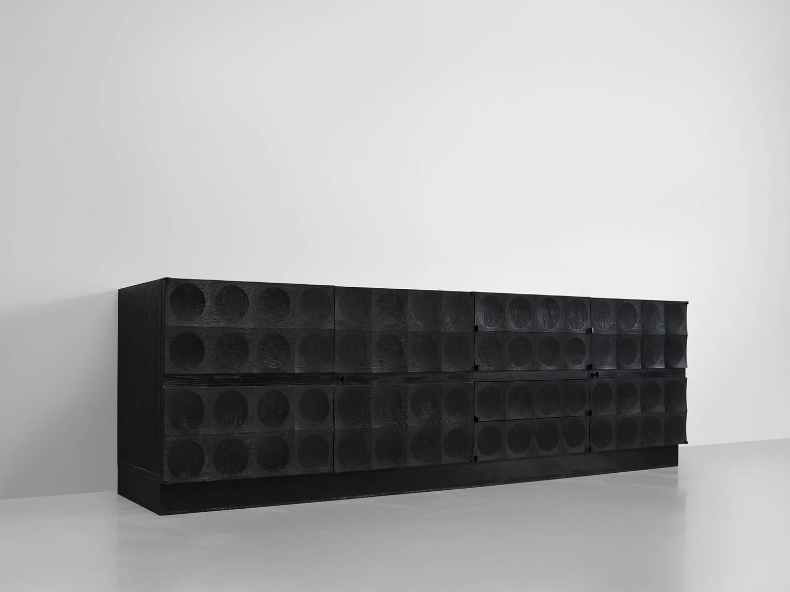 De Coene, credenza in ebonized oak, Belgium, 1970s. 

This large graphical stained black sideboard in oak is designed by De Coene Frères. This Brutalist credenza shows a beautiful graphical front. Each of the doors is ribbed and decorated with