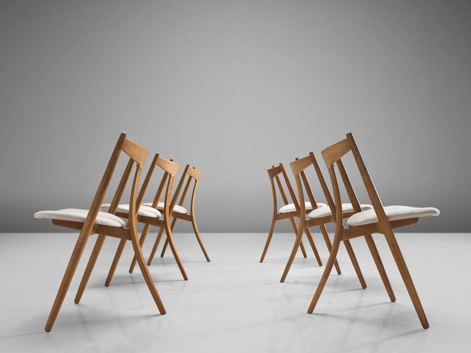 Dining chairs, teak and oak, Denmark, 1950s.

This set of six chairs is made by a cabinetmaker in Denmark. The chairs have a tripod frame made of oak and a backrest executed in teak. The chairs main characteristic is the bent single back leg. The