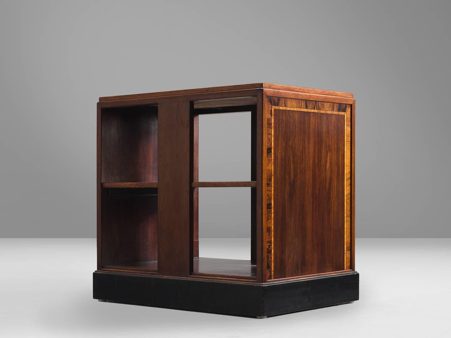Showcase, mahogany, rosewood, walnut, Europe, 1950s.

This small, square cabinet features different inlays of wood. The main cabinet is made out of mahogany but the side are very decorative and graphic and the border is executed in cocobolo and the