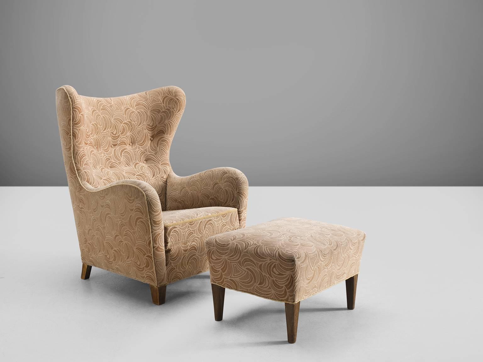 Thorald Madsen for Fritz Hansen, fabric and wood, Denmark, 1942. 

Classical high back chair, with beautiful tufted back. The chair is combined with a matching ottoman which makes this a rare find. The design for Madsen is inspired on a
