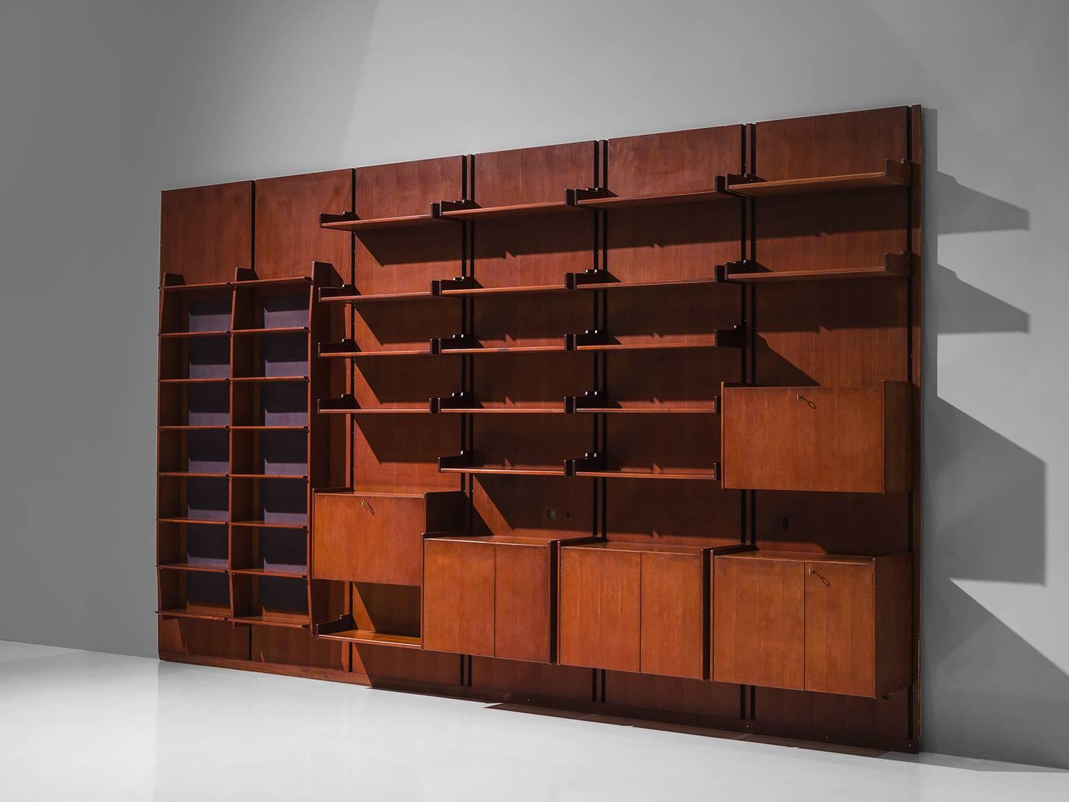 Shelving unit, teak, brass, metal, Italy, circa 1955.

This large 4.7mt/15.5ft  wall unit is made by an Italian artist and cabinet maker. The cabinet consists of six panels with various different storage facilities. There are five cupboards and many
