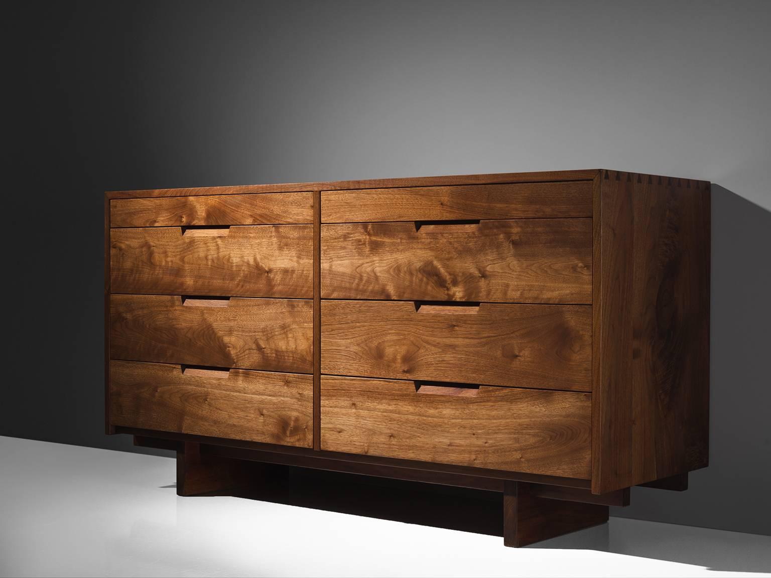 George Nakashima, cabinet in walnut, New Hope, PA, 1955.

This cabinet features eight drawers, executed in walnut with traditional and finished with archetypical dovetail Nakashima wood-joints. The cabinet rests on two slabs of solid walnut that are