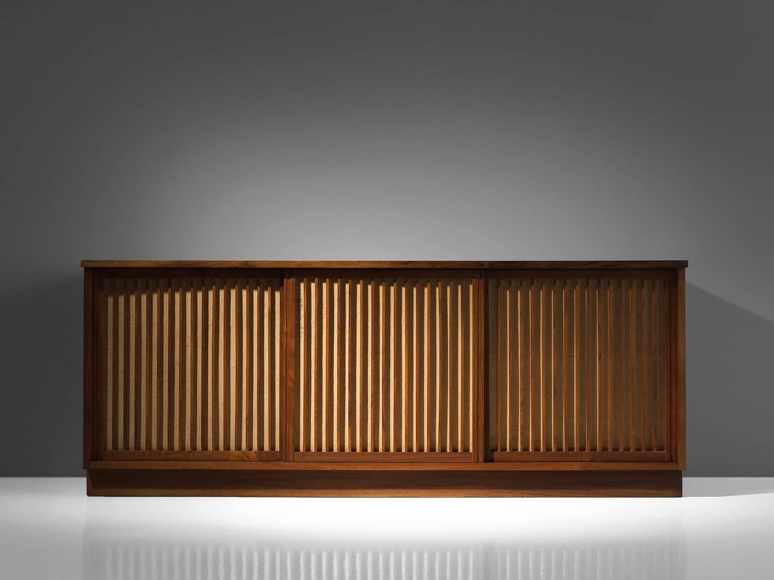 George Nakashima, triple sliding door cabinet, walnut, pandanus cloth, New Hope, PA, 1970

Cabinet with three sliding doors and several compartments behind each door, executed in walnut with traditional and archetypical dovetail Nakashima