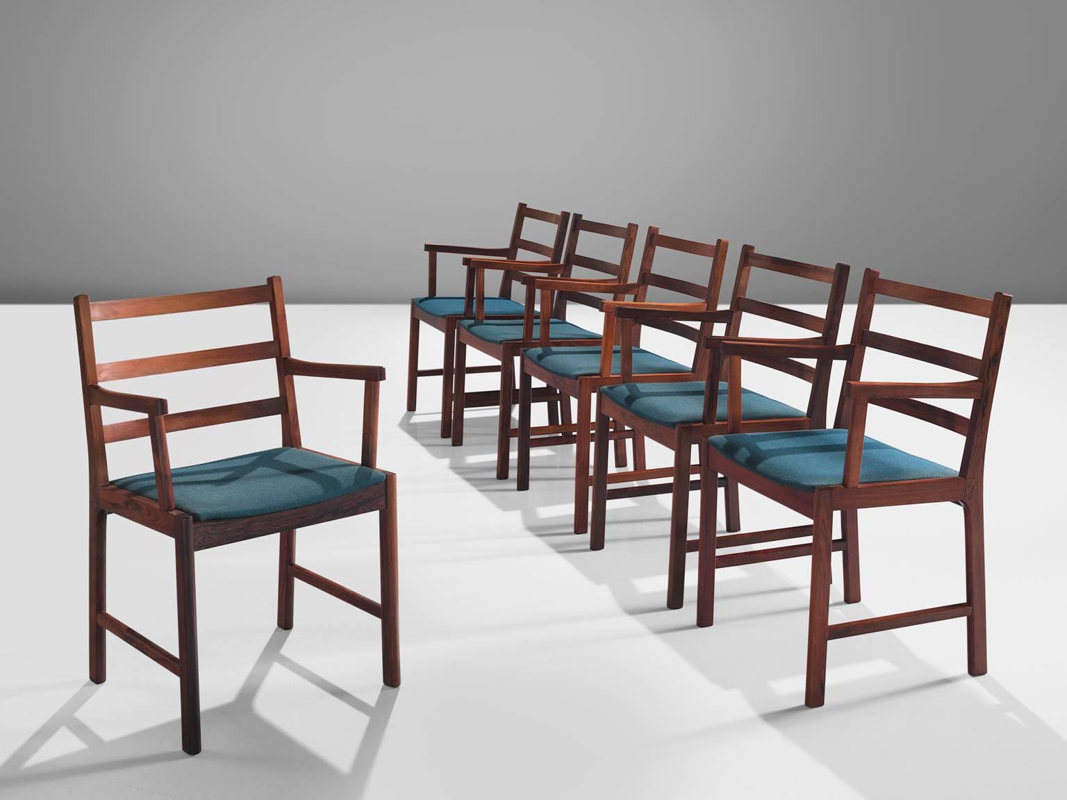 Set of six armchairs, rosewood and blue wool, Denmark, 1960s.

This set of rosewood chairs have a warm grained frame. The chairs are built up of a slatted back with three slats and a minimalist, clean frame. The warm color of the wood combines great