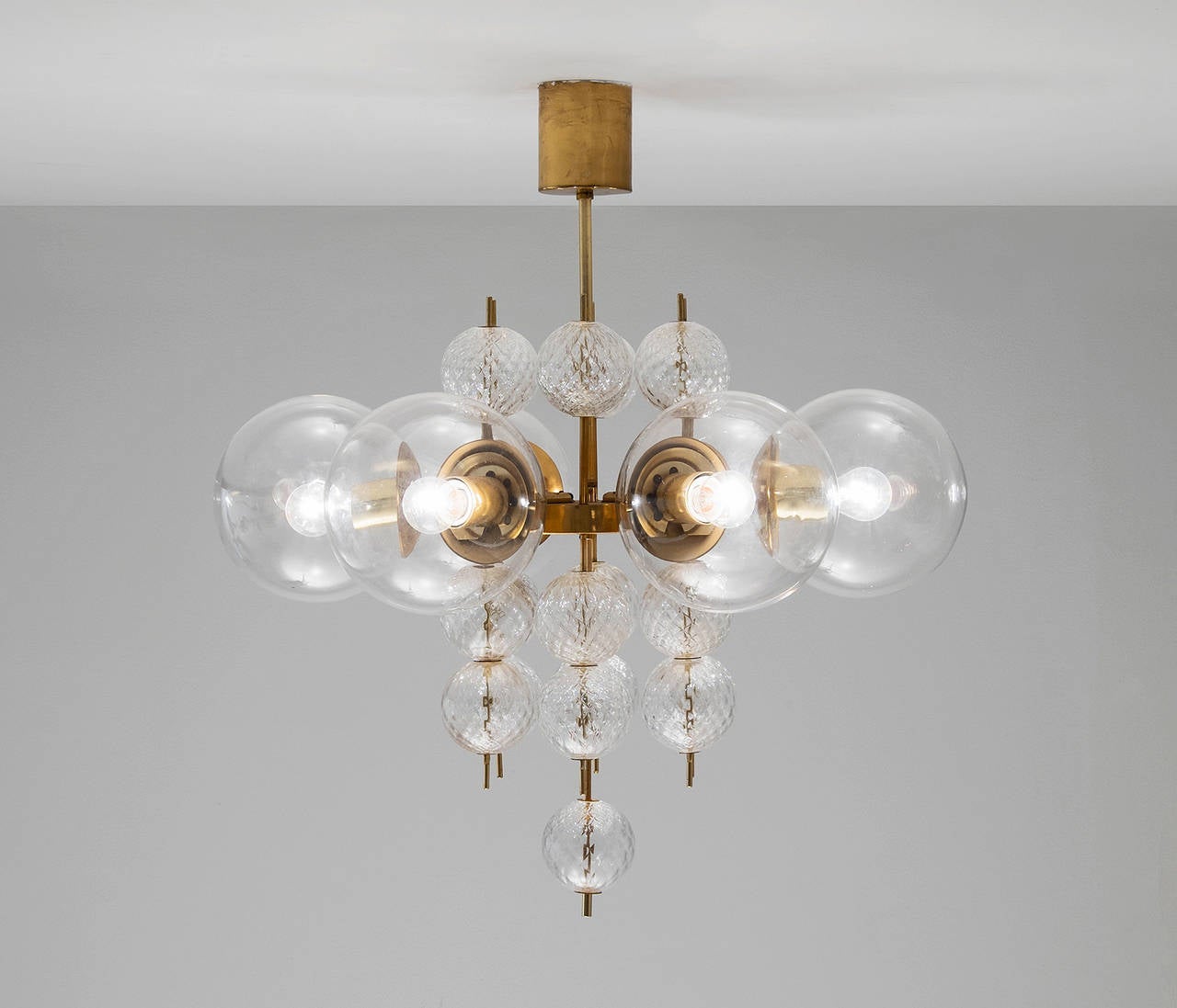 Chandelier, brass and glass, Europe, 1960s.

This light was found in the very south of the Czech Republic, so most likely from Austrian production seen its excellent quality with which it has been manufactured. Multiple large bulbs are dynamically