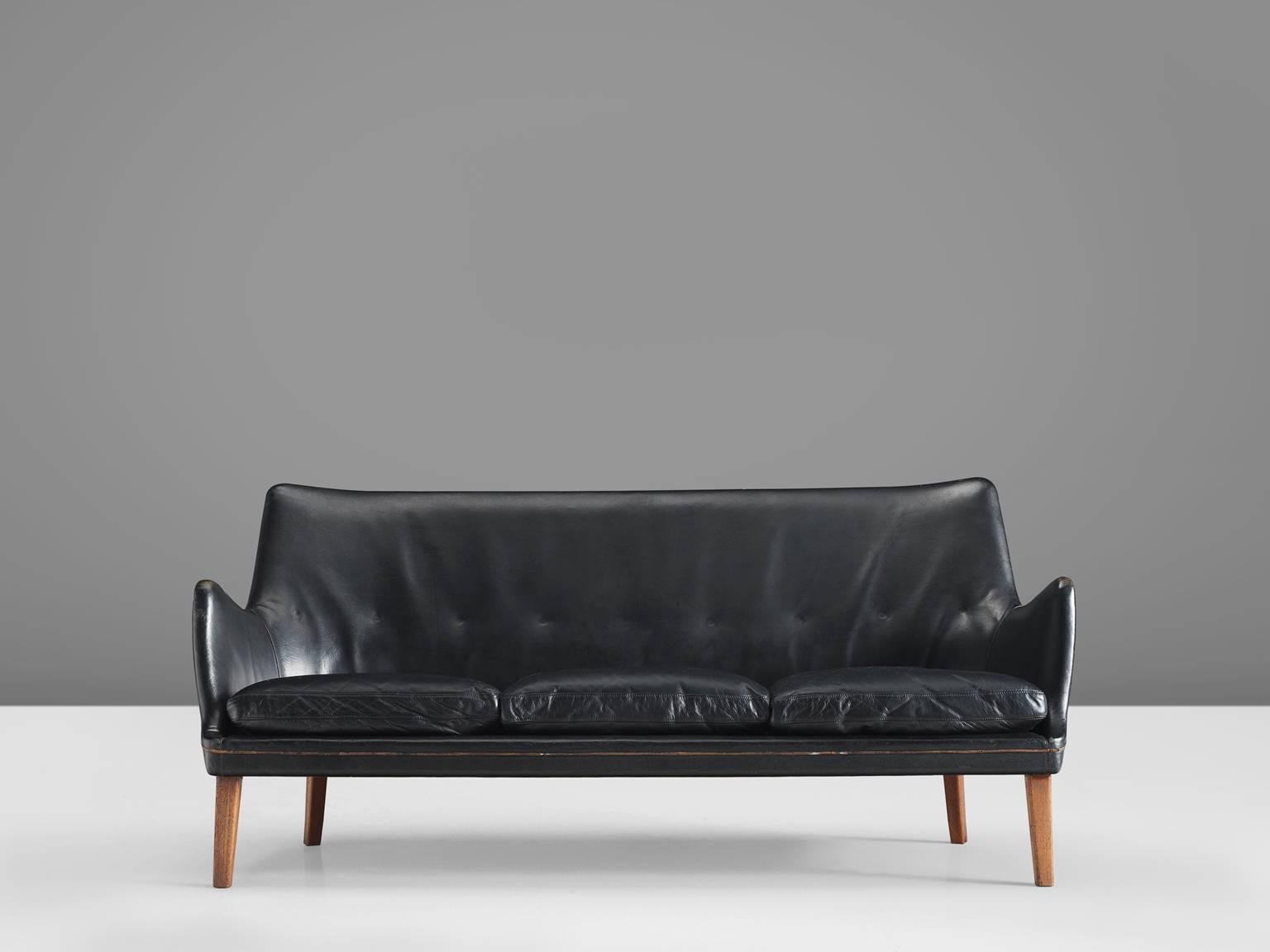 Arne Vodder for Ivan Schlechter, sofa, black leather and wood, Denmark, 1953.

Elegant three-seat sofa in black leather by Danish designer Arne Vodder. This sofa shows the great craftsmanship of Arne Vodder. The seating and back features organic