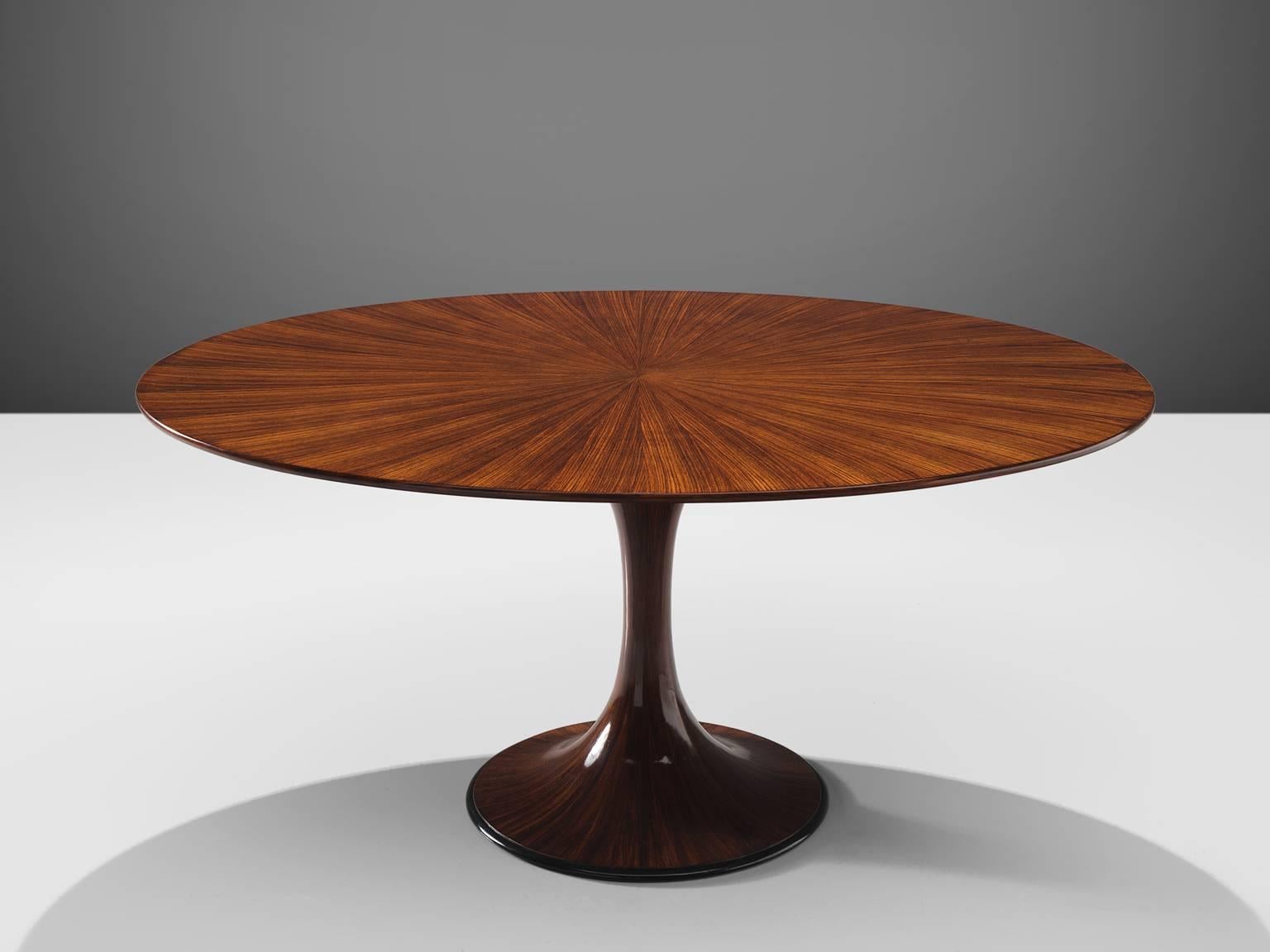 Luigi Massoni, table à manger ovale, bois de rose, Italie, vers 1950.

Cette table ovale présente un pied sculptural fin et doux. Le motif de ce tableau est créé en plaçant plusieurs pièces sciées à plat en forme d'étoile. Grâce à cet astucieux