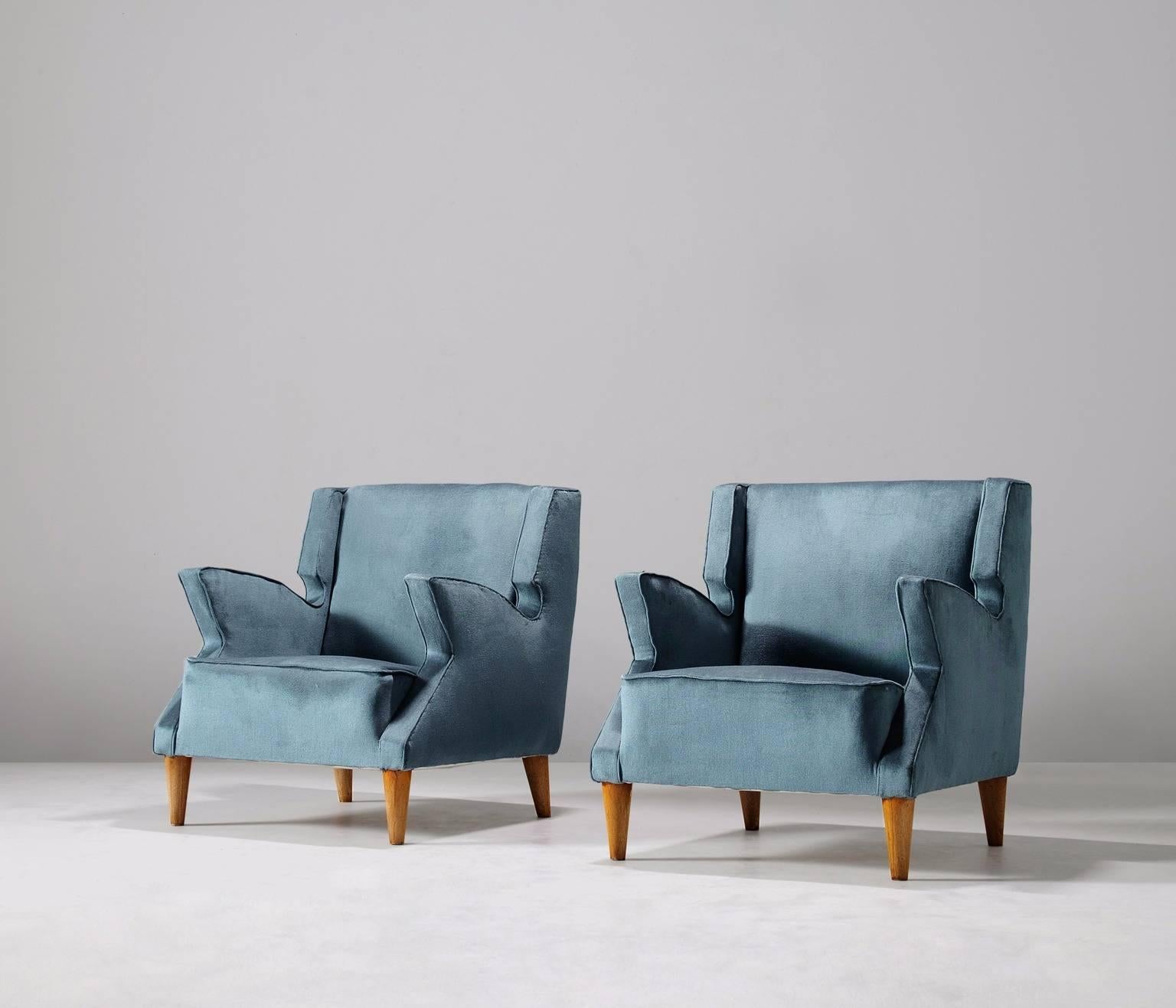 Pair of two armchairs, in fabric and wood, Italy, 1950s. 

Set of two lounge chairs which show a variety of very well designed sharp lines which provide each chair with an uncommon yet elegant look. Special attention towards the armrests which