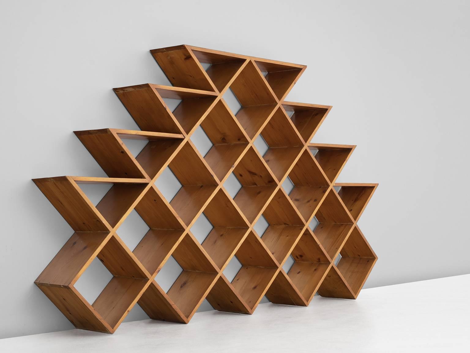 Wall unit, in pine, Europe 1960s. 

Graphical bookcase in solid pine. These shelves consist of several piled cubes formed into a pyramid. The diagonal lines are alternate by horizontal lines on the sides of the cabinet. A beautiful rhythm is