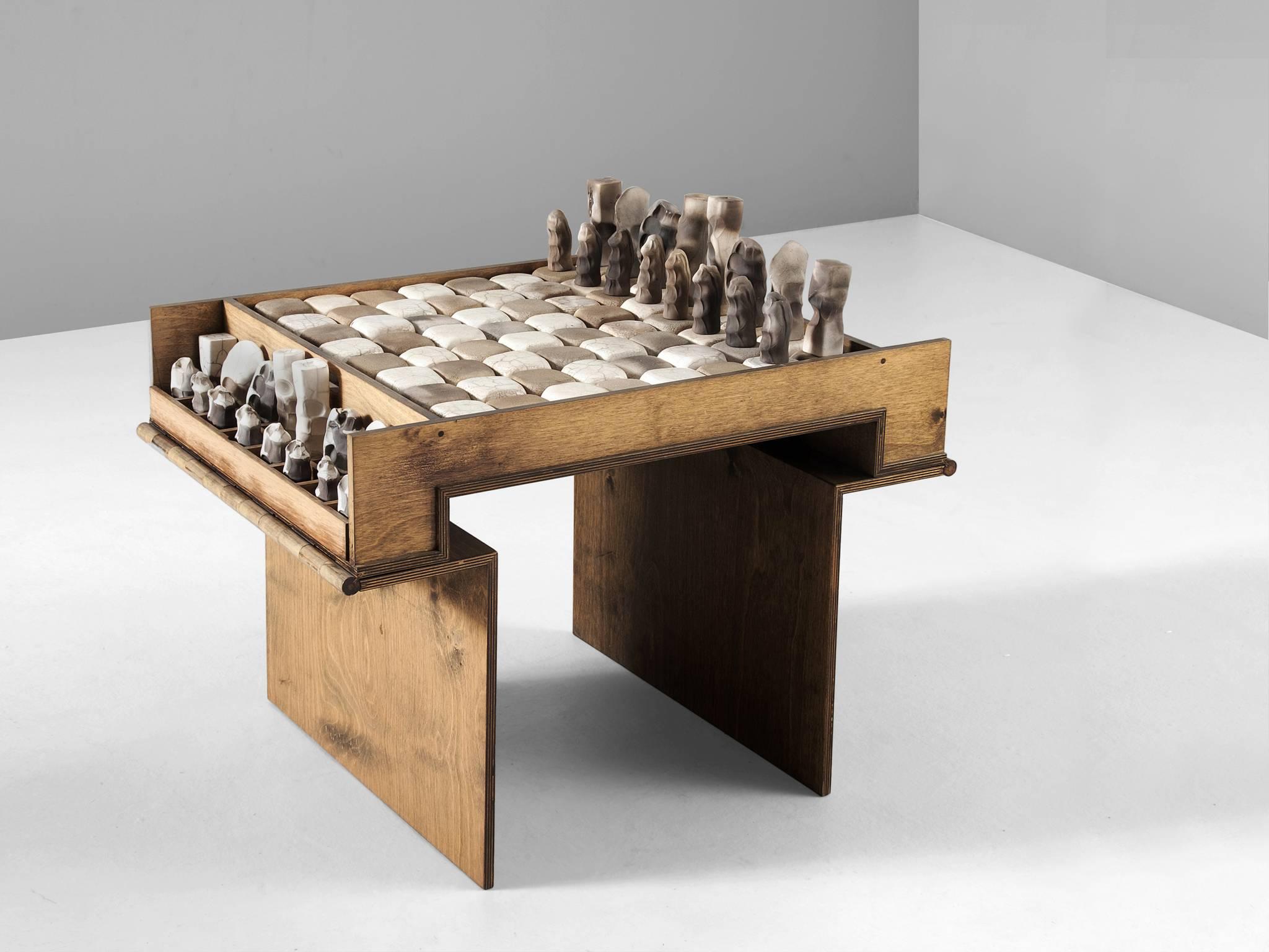 Chess game, in ceramic and wood, Italy, 1950s

Exceptional game of chess. The birch plywood table holds the ceramic chess board and pieces. The wooden table can be fold into a chest. A checkered board of white and black ceramic blocks. All chess