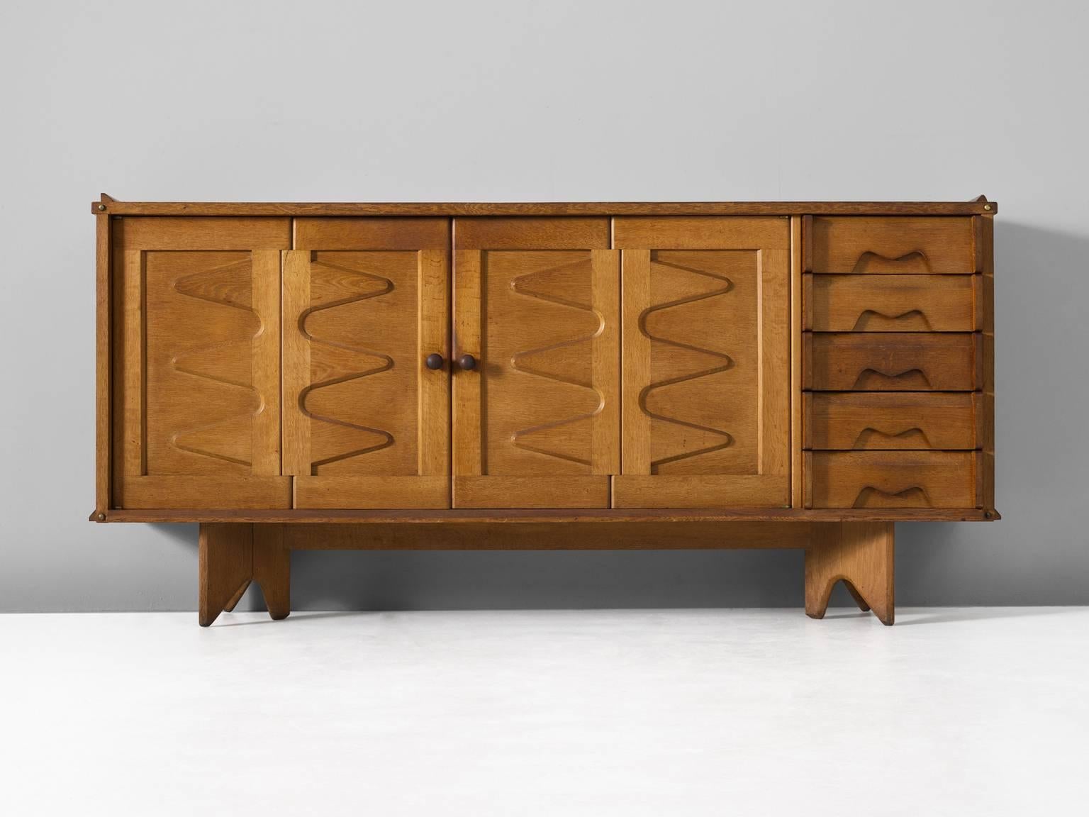 Sideboard, in oak, by Guillerme et Chambron for Votre Maison, France, 1960s. 

Credenza with graphical door panels by French designer duo Guillerme and Chambron. The four doors show an interesting zigzag-pattern. The differences of depth create a