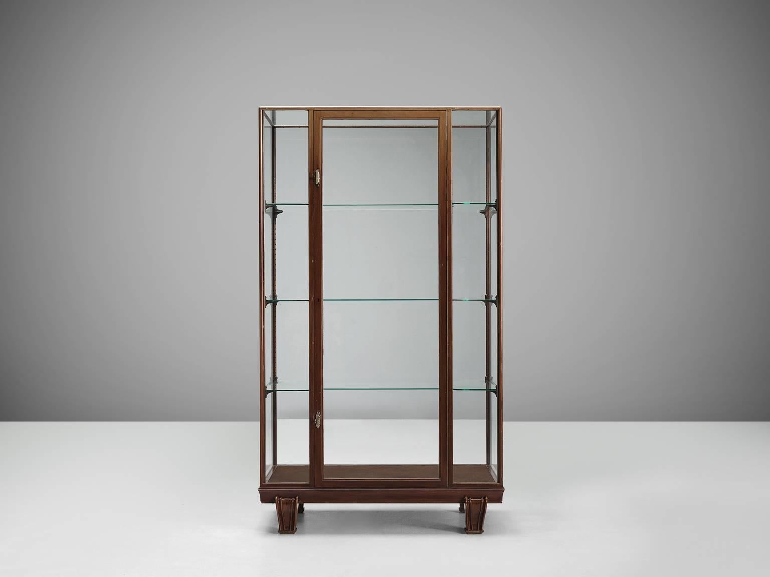 Vitrine, wood, glass, steel, Europe, 1960s.

Sturdy and Minimalist showcase in glass and wood. The base of this vitrine is beautifully simply designed as it features a wooden foot that is built up of four sturdy feet. The middle panel features a