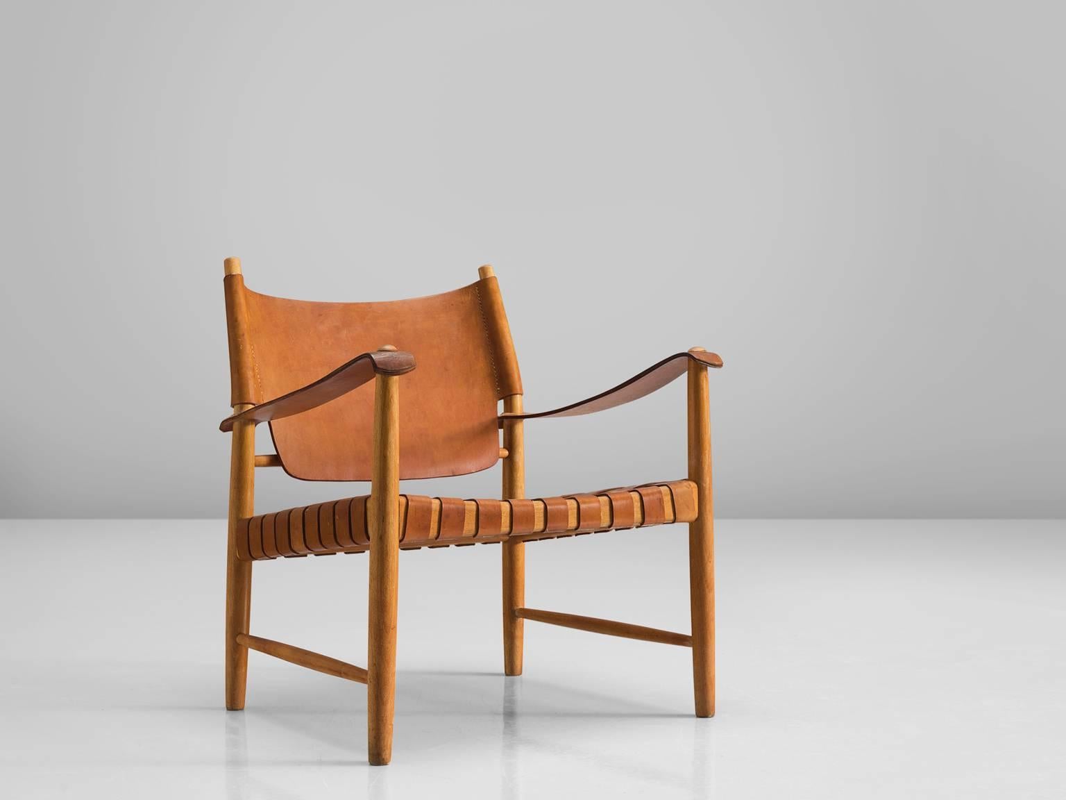 Safari chair, leather, beech, Denmark, 1950s.

This elegant safari chair features wonderful patinated leather on both seat and back. The patina on this chair creates a vibrant look and the straps in the seat form a thick, well-constructed yet