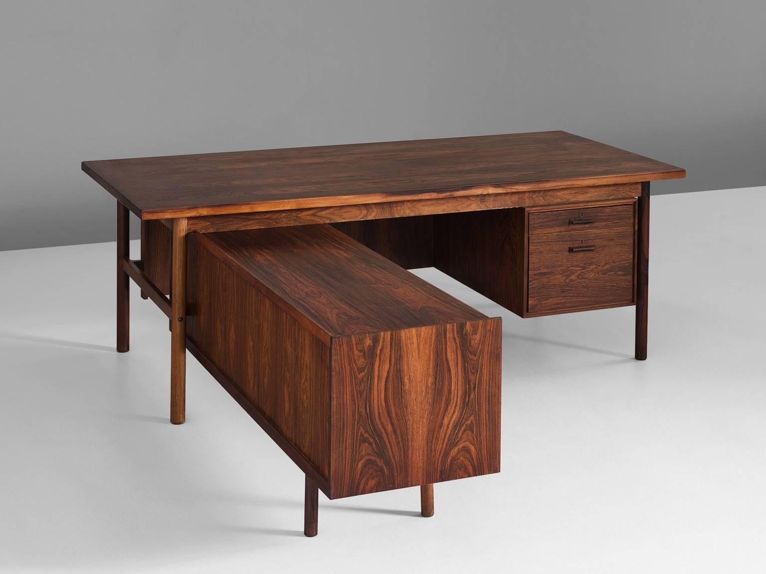 Ib Kofod-Larsen for Brande Møbelfabrik, executive desk, rosewood, Denmark, 1960s. 
 
The L-shaped desk consists of a higher and lower part with several drawers and shelves. The desk shows some nice crafted details. The return is situated on the