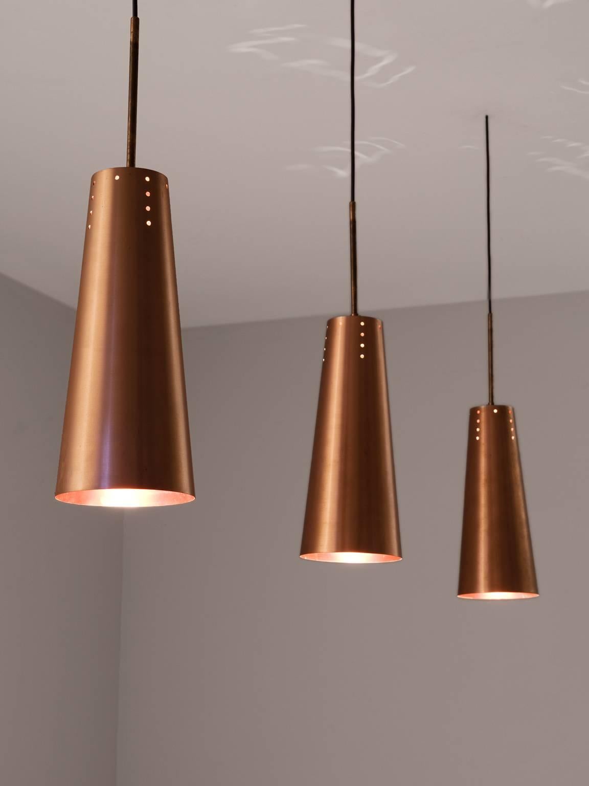 Pendants, in copper, Europe 1980s. 

Set of solid copper pendants. A simplistic design with all the attention for the material. The shade of solid copper is cone shaped. Small perforations on the top are a playful addition. By the copper on both