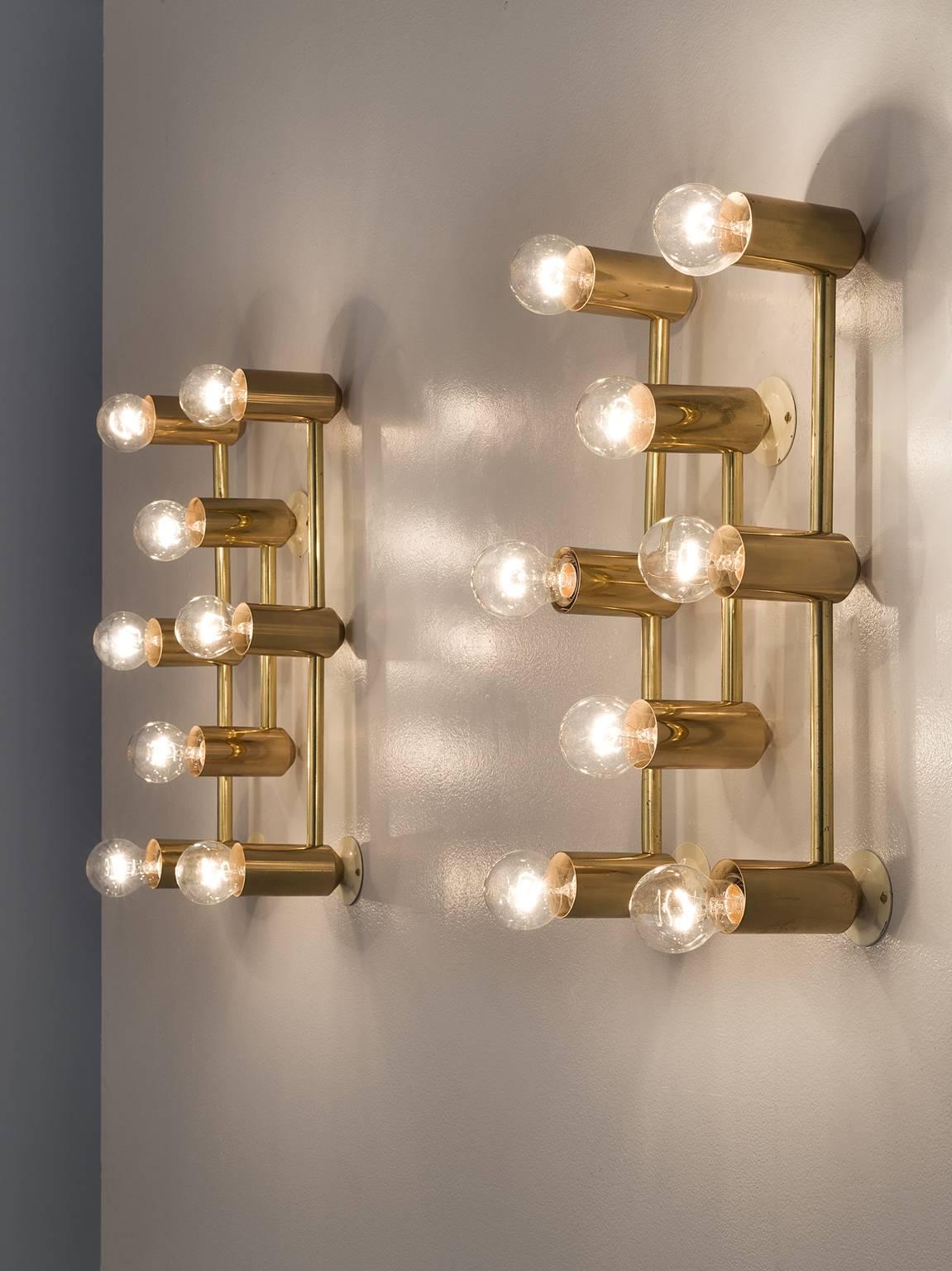 Wall lights, brass, 1960s, Europe.

This set of delicate wall lights are Minimalist yet warm. Each light consists of eight light bulbs that are placed in three rows of which the middle section holds only two and the outer three. The light source