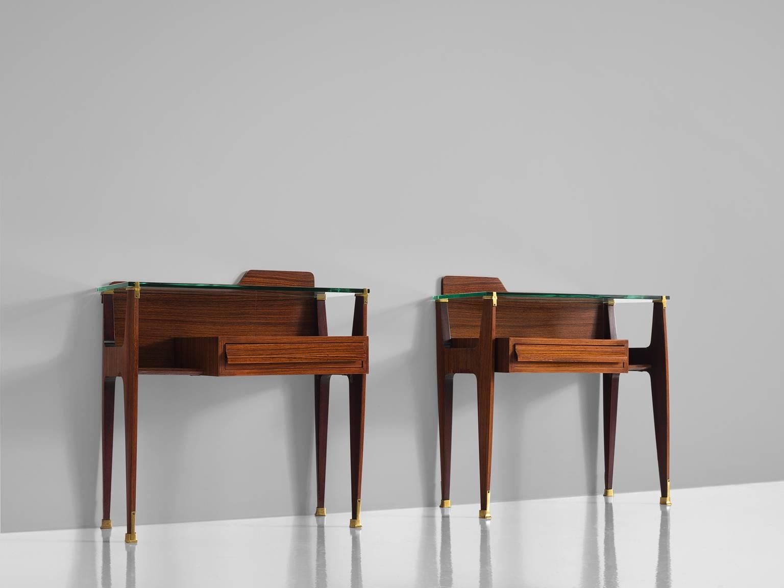 Nightstands, wood, glass and brass, Italy, 1950s.

These two side tables or nightstands are both refined and elegant in every way. The glass top stretches a little but over the outer edges of the solid, precisely crafted oak legs. These sculptural