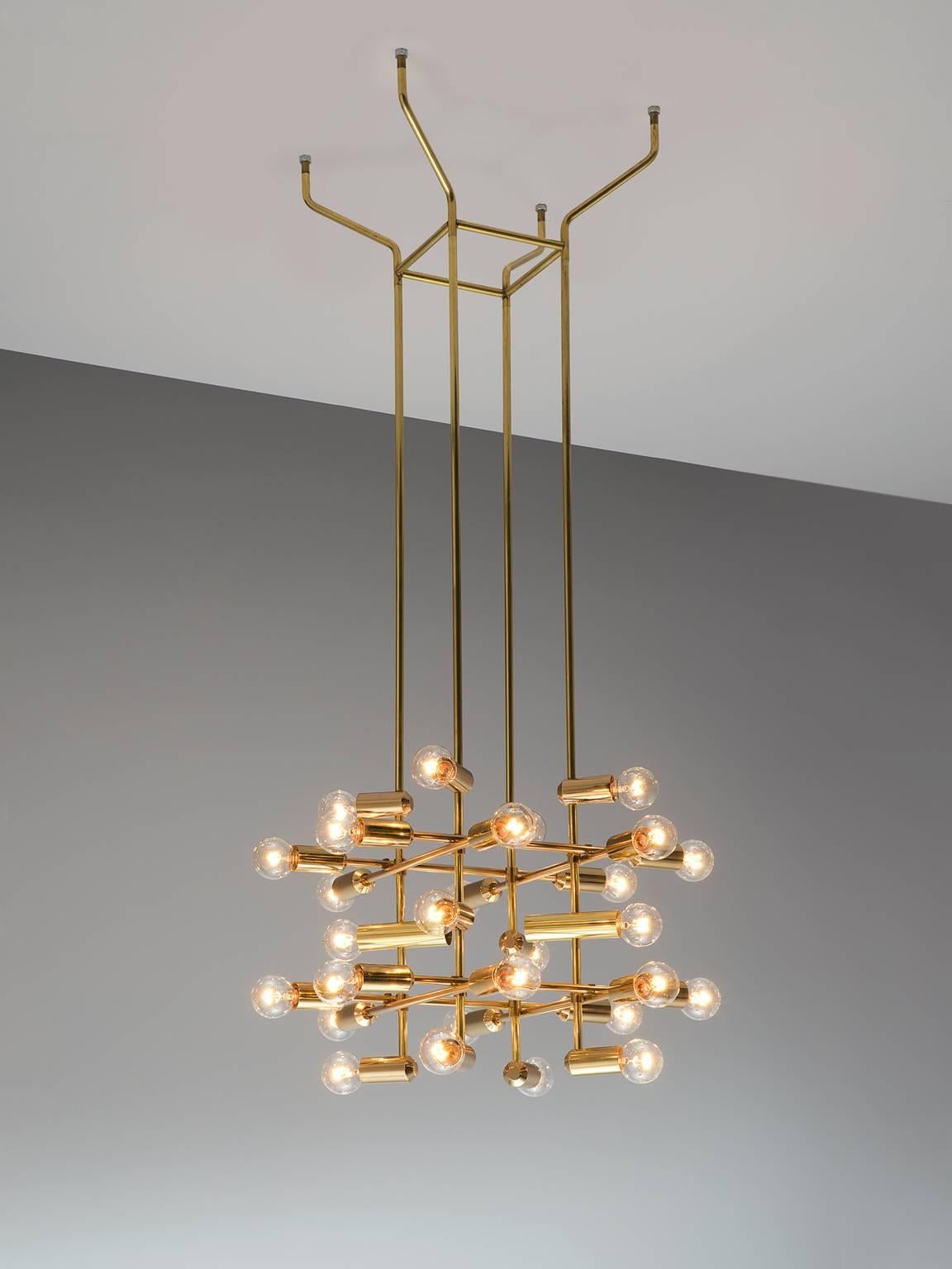 Chandelier in brass, Switzerland, 1960s.

This delicate chandelier is Minimalist yet warm. Each light consists of 28-light bulbs that are placed on the ends of brass horizontal beam. The beams form a cross-like pattern that is attached to the