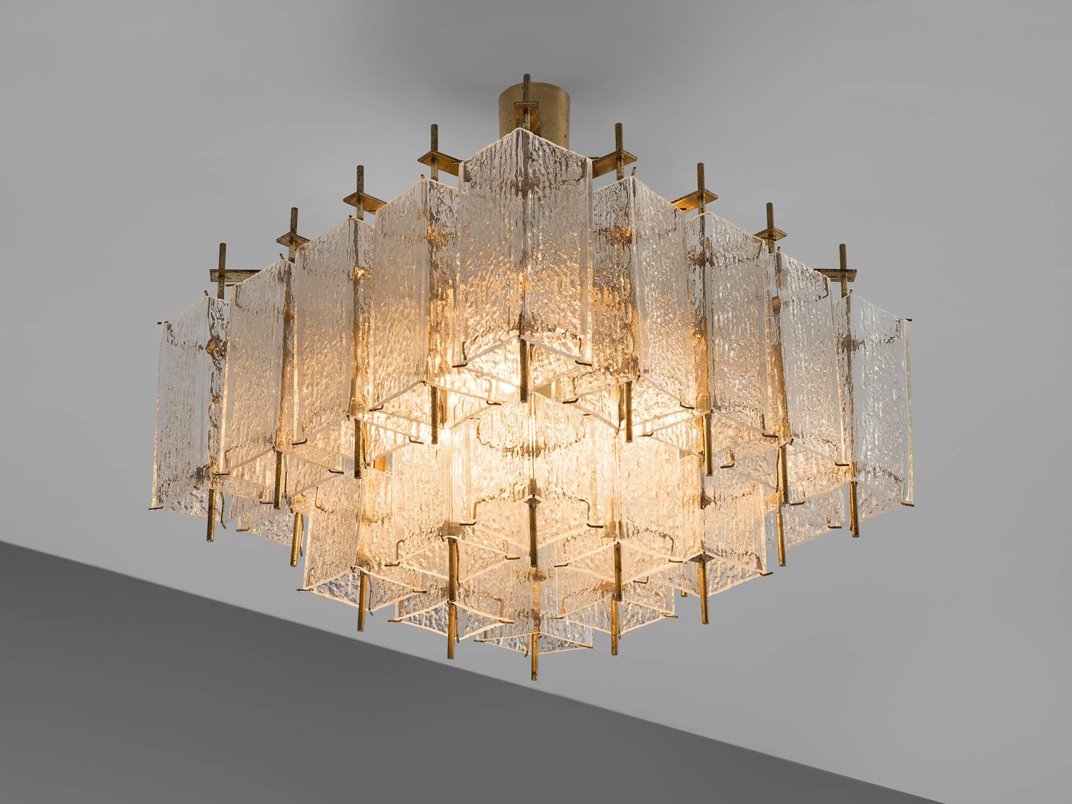 Chandelier, in glass and brass, Europe, 1970s. 

This elegant square chandelier features a great amount of rectangular structured glass shades and a rectangular brass fixture. The frame is made of brass and holds brass pipes that have structured