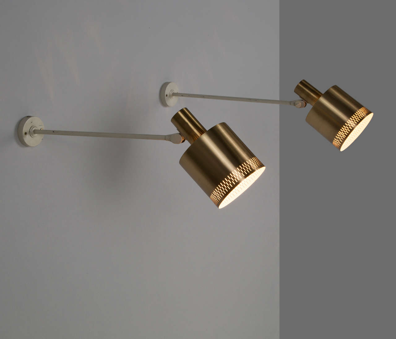 Wall lamps, brass shades white metal body, Sweden, 1950s.

The shades are adjustable so both the wall and the surrounding room can be illuminated. There are very nice perforated details in the brass shades which provide a nice and warm ambient