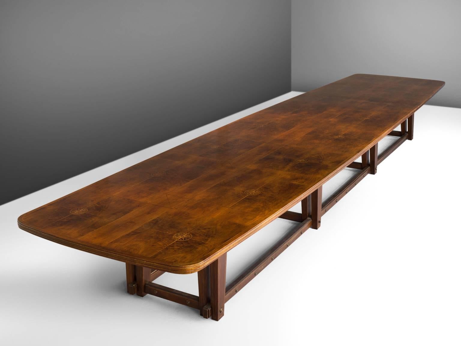 Conference table, in walnut, Europe, 1950s.

Extremely large conference table in walnut. The top show beautiful inlaid wood. A geometric pattern is created due horizontal and vertical lines. Replenished with the illustration of compass-card. The