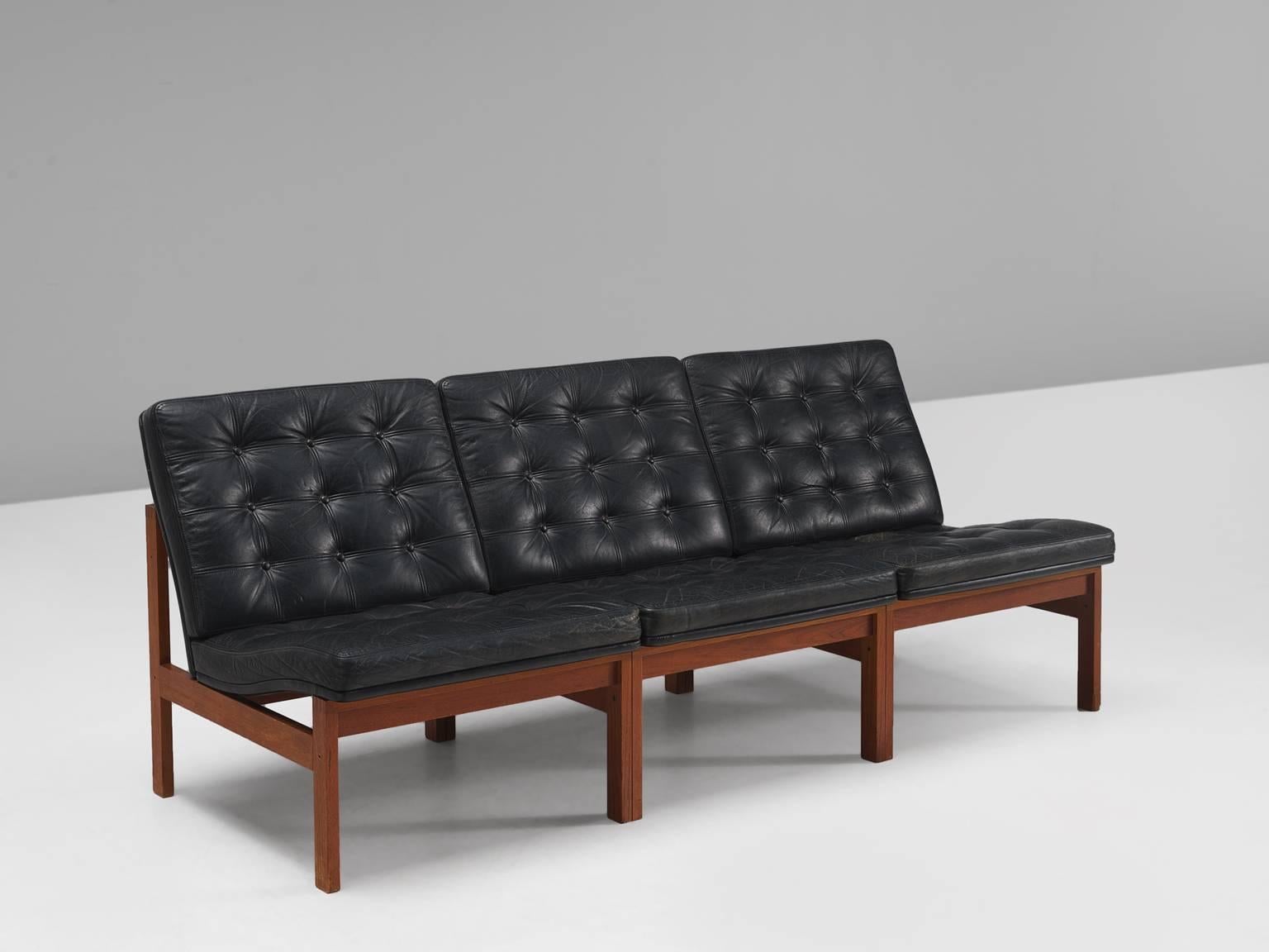 Ole Gjerløv-Knudsen & Torben Lind for Fritz Hansen, leather and rosewood, Denmark, 1962 

Modern and beautiful black leather sofa. The piece resulting in a crisp yet warm design. The rosewood frame holds a black leather body with buttoned