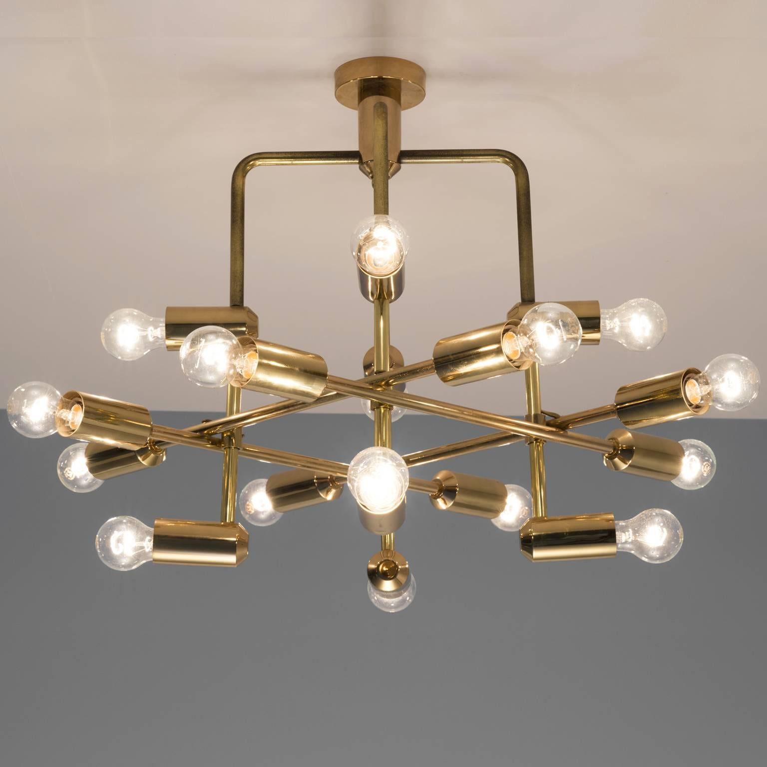 Swiss chandelier in brass, Switzerland, 1960s.

This delicate chandelier is minimalist yet warm. The light consists of multiple light bulbs that are placed on the ends of brass horizontal beam. The beams form a cross-like pattern. The light source