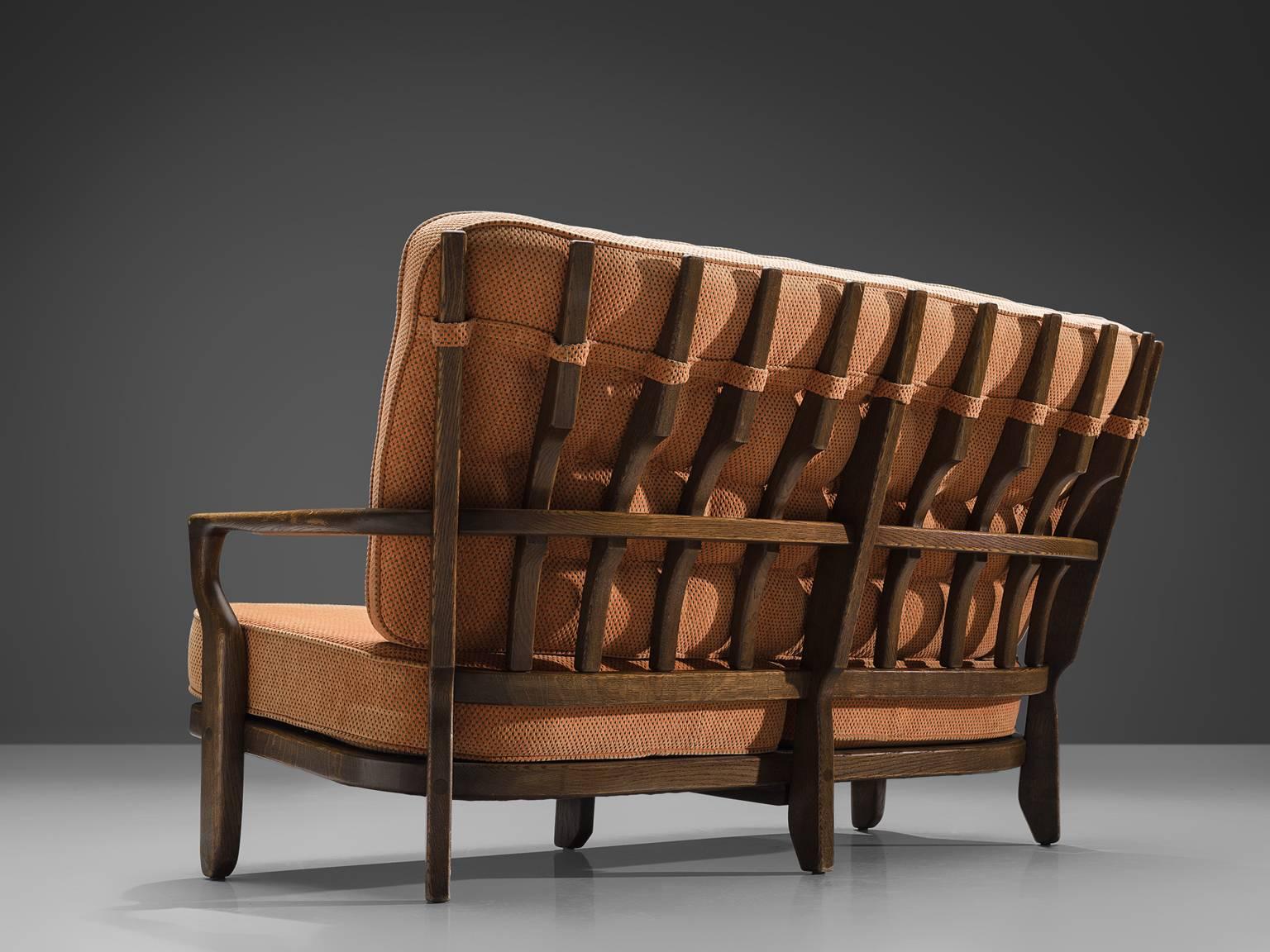 Guillerme and Chambron, peach, pink fabric, oak, France, 1950s

This sculptural carved oak settee is designed by Guillerme and Chambron. The design duo is known for their sculptural, crafted solid oak furniture. This comfortable sofa has an