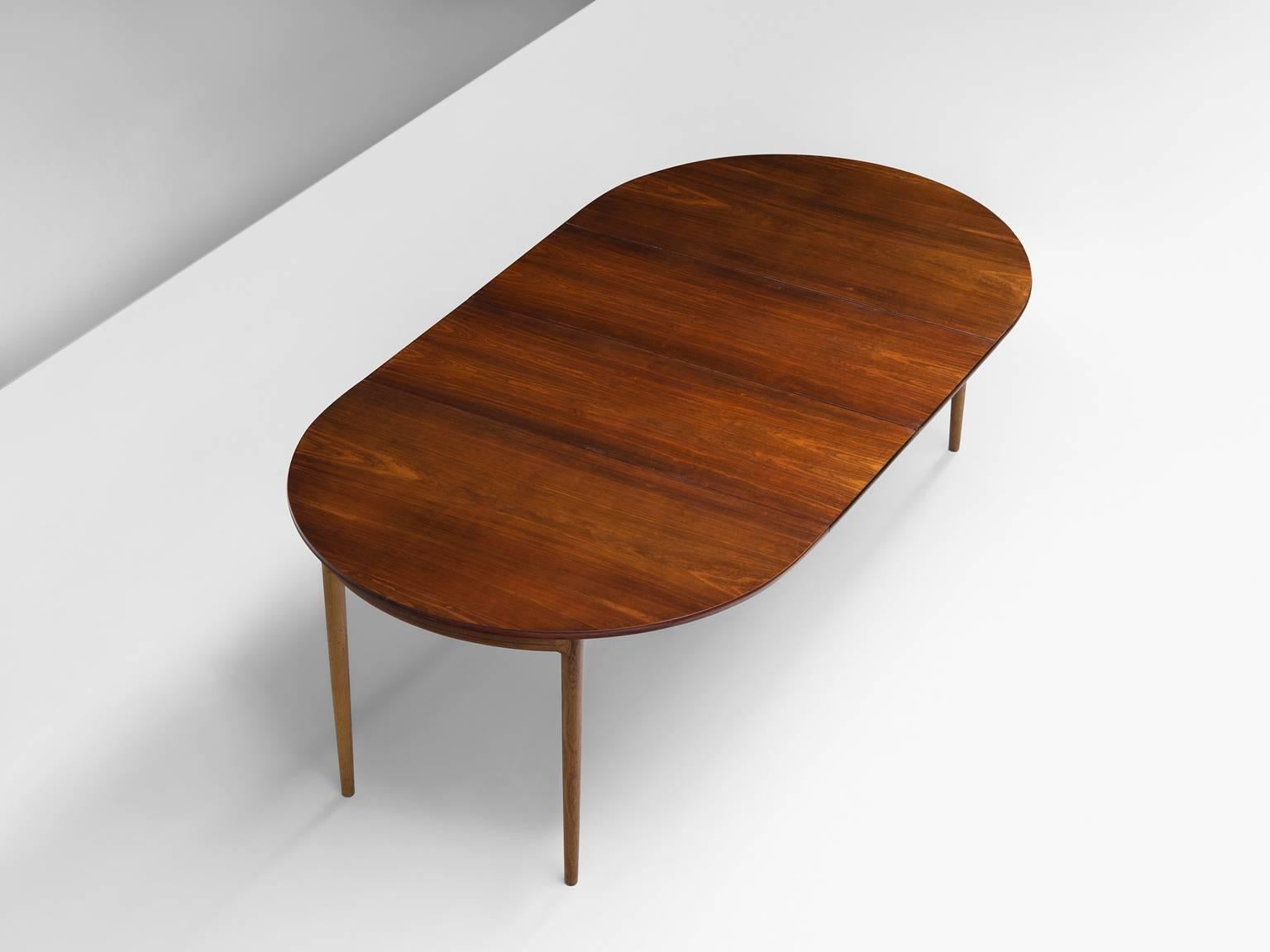 Table, rosewood, Denmark, 1950s.

This archetypical Midcentury Danish dining table is oval and extendable. Ib Kofod-Larsen designed this Classic oval table for Faarup Møbelfabrik. The table's main feature is the rosewood grain and flames that flow