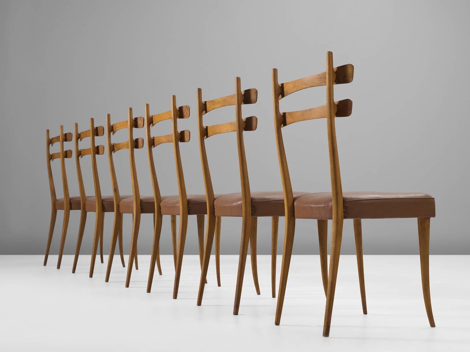 Set of dining chairs in oak and leather, Italy, 1940s. 

These Italian chairs are both minimal and playful due to the double beamed seat back. The slender legs taper towards the bottom. The airy dimensions and forms are misleading, each chair