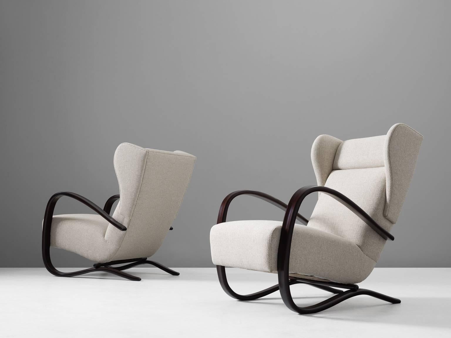 Jindrich Halabala, pair of armchairs, in stained beech and fabric, by  Czech Republic, 1930s. 

This Halabala chairs are part of our midcentury design collection. These lounge chairs have a very dynamic appearance, due the curved base that ends